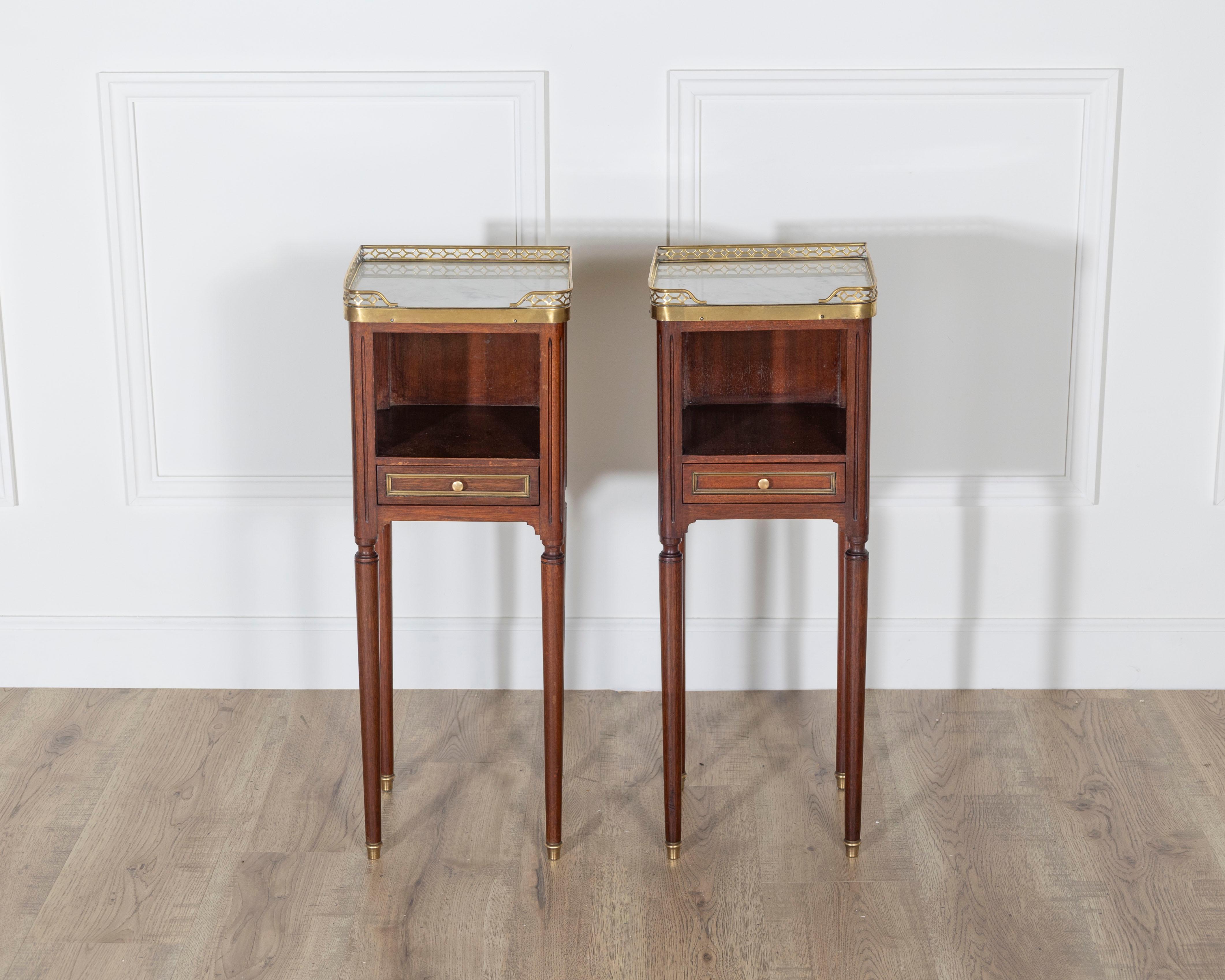 Questa elegante coppia di piccoli comodini in stile Luigi XVI esemplifica la raffinatezza neoclassica e le proporzioni equilibrate del design francese della fine del XVIII secolo. Realizzato in pregiato mogano, ogni pezzo si apre sul davanti con una