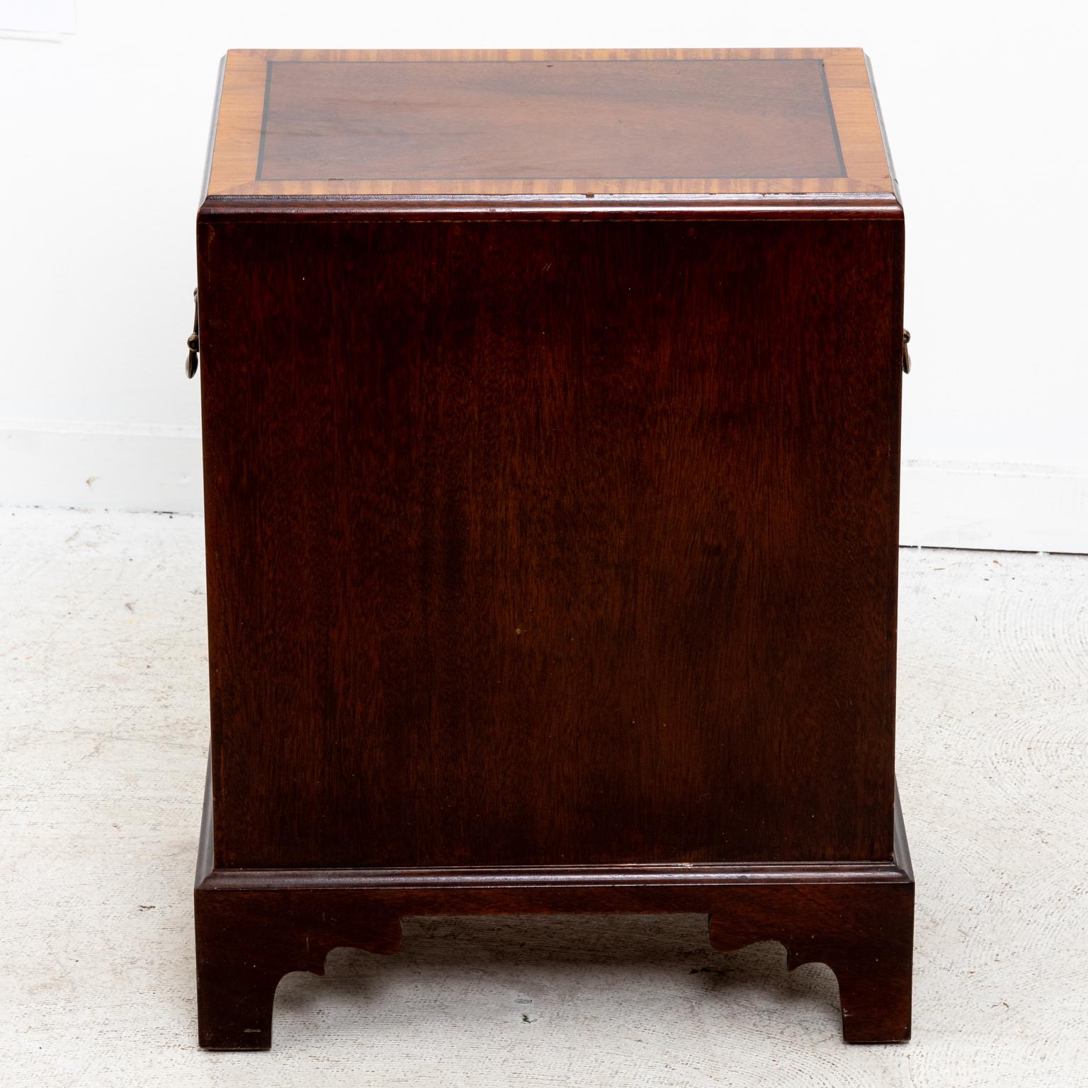 Pair of small size mahogany three-tier chest of drawers featured with metal handles on the drawer fronts, light wood accent trim, and bracket feet. The chests also come with metal handles on the sides for transport. Please note of wear consistent