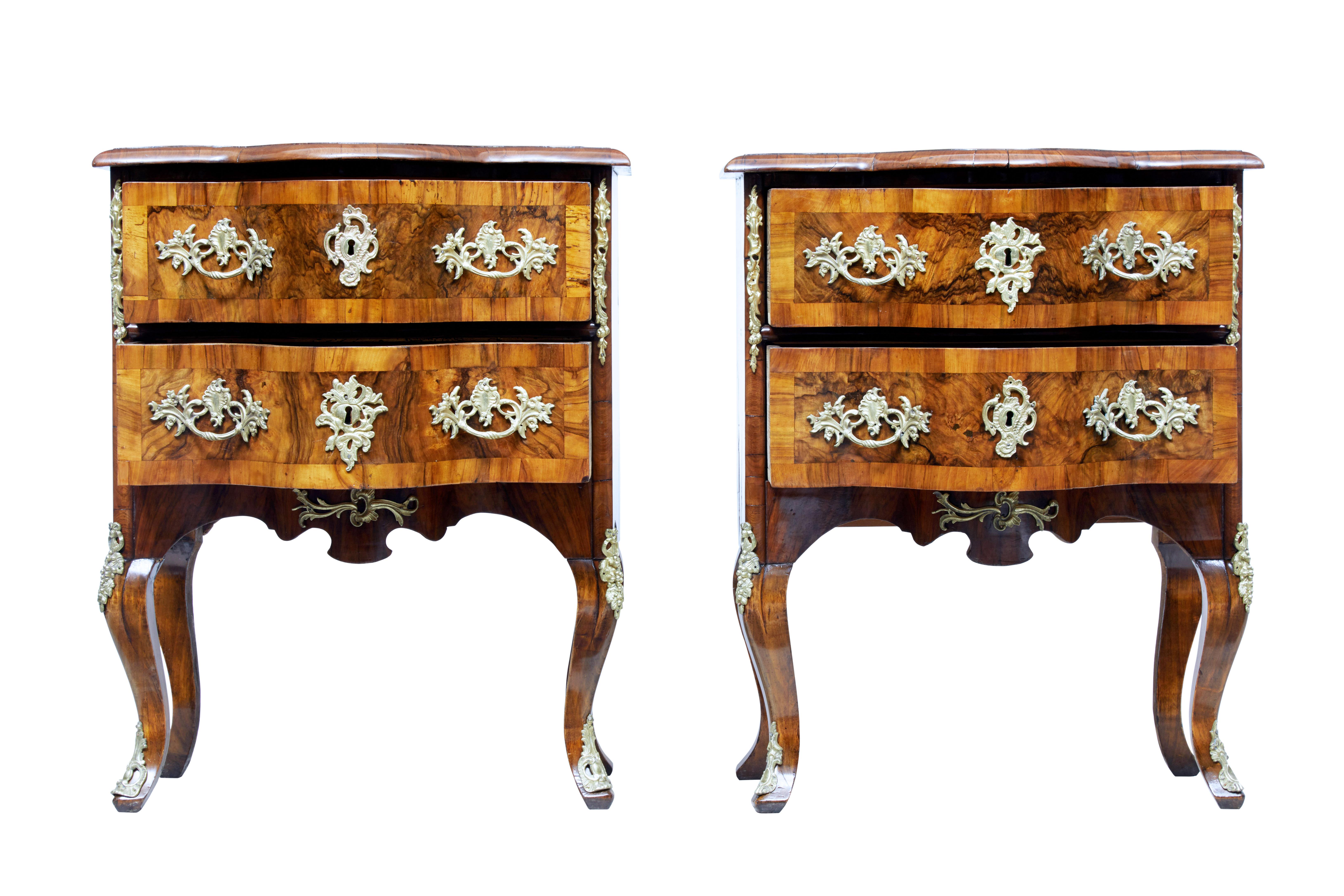 Fine pair of German walnut serpentine commodes, circa 1860.

2 drawers fitted with ornate ormolu handles. Escutcheon and further mounts to sides and legs.

Top surface with segmented walnut veneers with burr cross banding. Burr drawer fronts