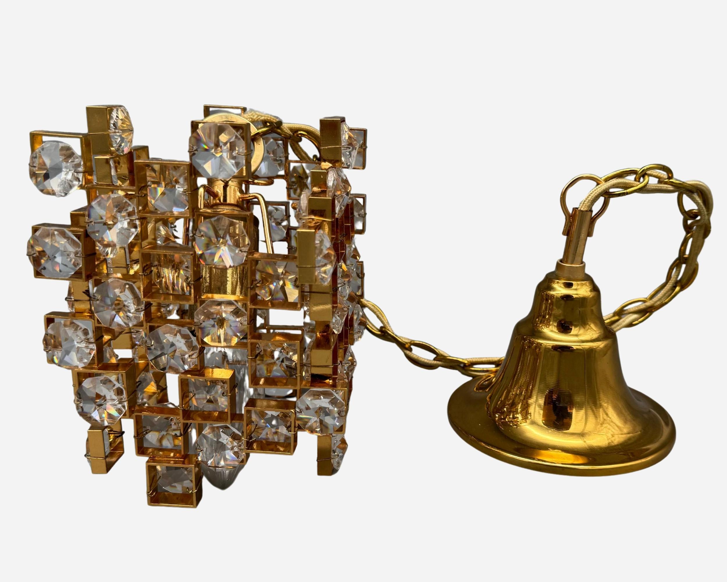Pair of small modernist lantern-shaped chandeliers, in gilded brass and crystals.
One light.

Total height: 88 cm (34.64 inches)
Height without chain nor pavilion: 16 cm (6.3 inches)
Width: 13 cm (5.12 inches)
Depth: 12 cm (4.72 inches)

Biography :