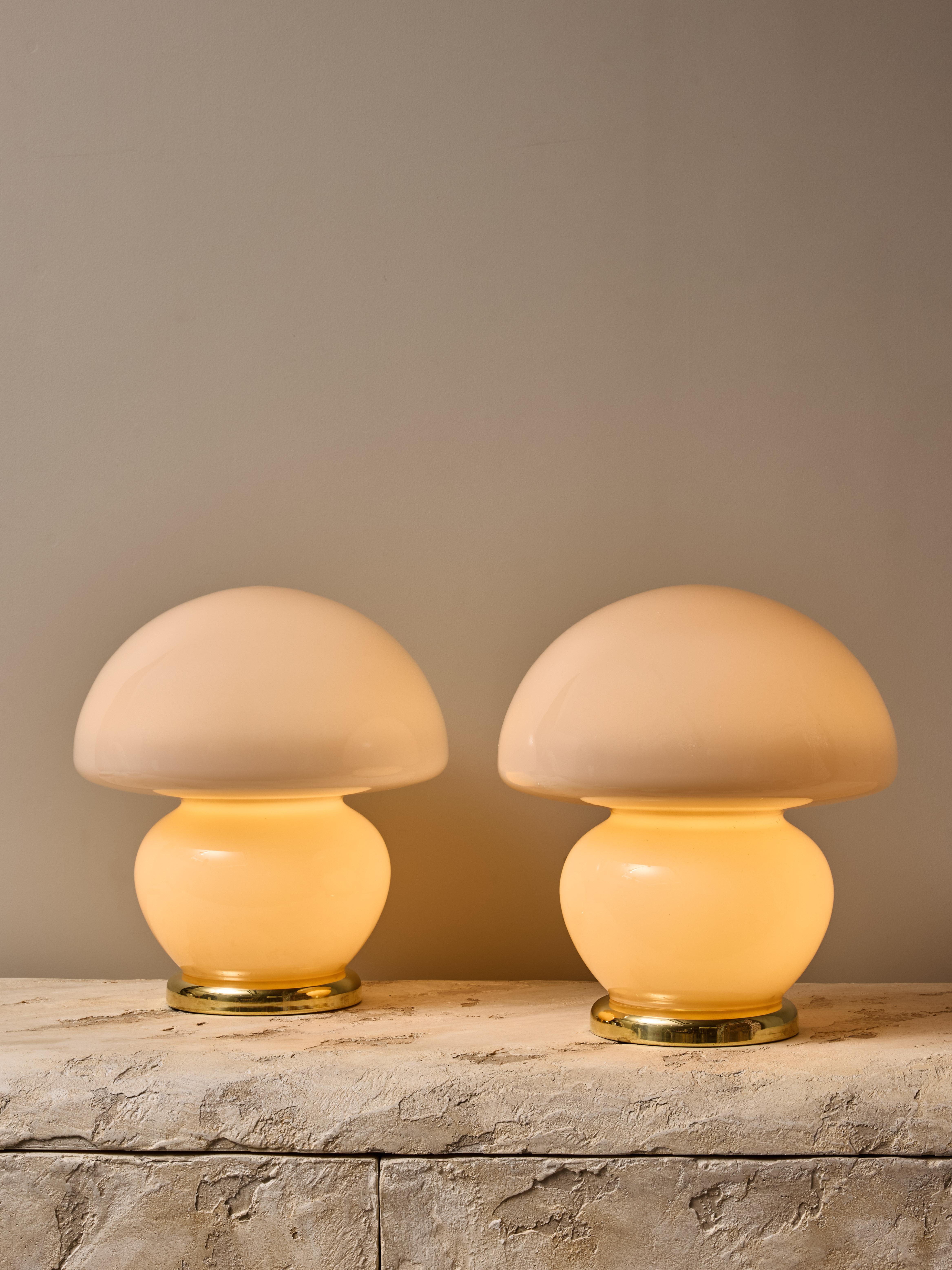 Pair of lovely table lamps, made of a single piece of Murano glass tinted in light pink, sat on a brass base.