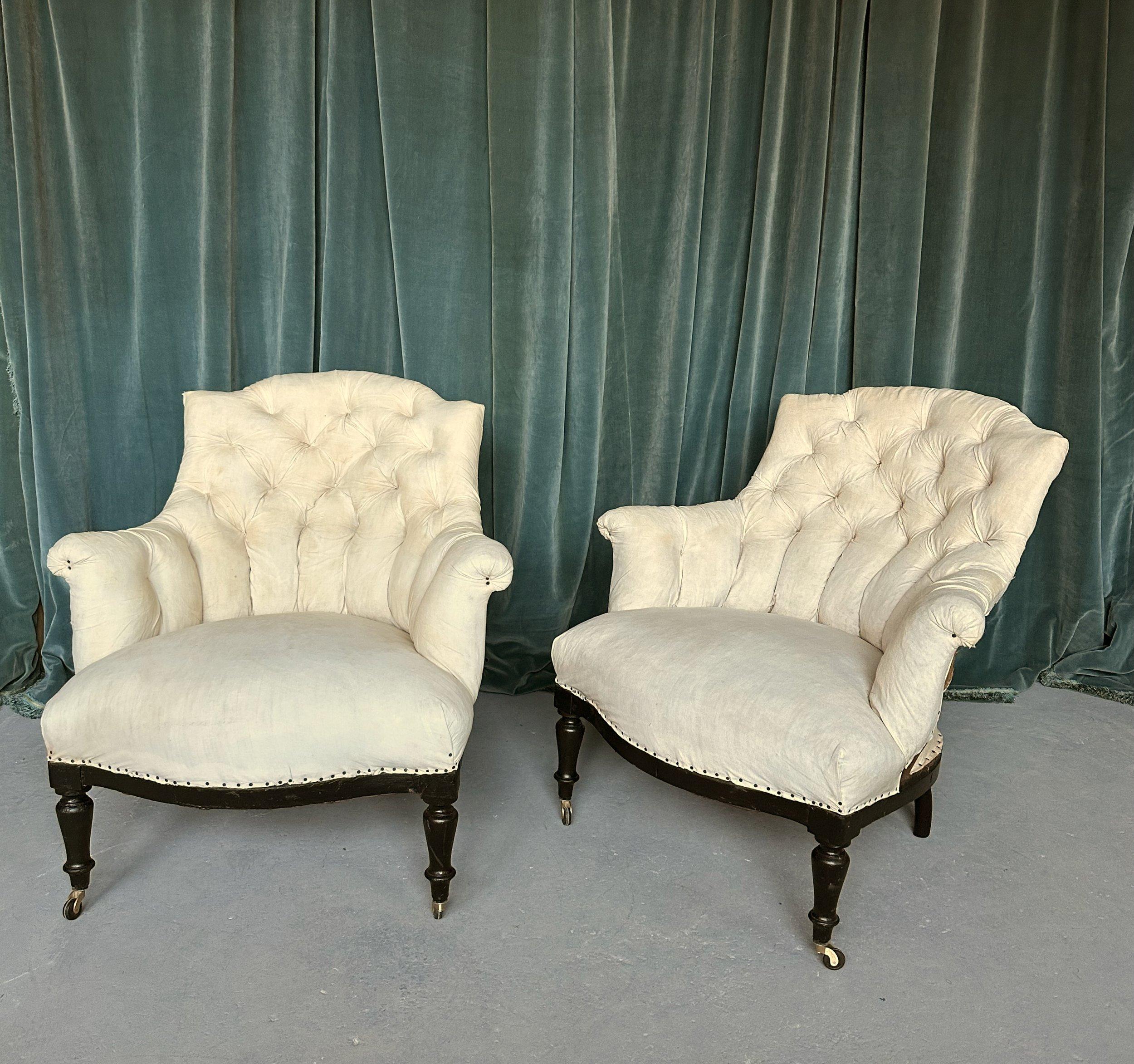An elegant pair of small scale French 19th century armchairs with diamond tufted backs and scrolled arms. This pair of armchairs from the Napoleon III period features the 