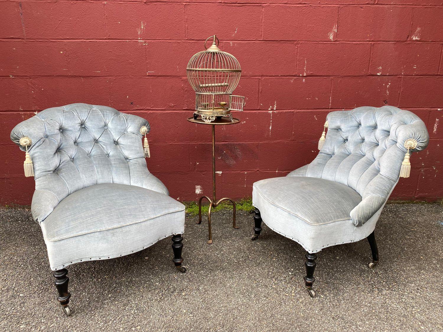 An elegant pair of small scale 19th century armchairs in pale blue. The chairs are classic French Napoleon III style, boasting tufted backs and tassels for added elegance. The pale blue upholstery provides a muted yet sophisticated touch that will