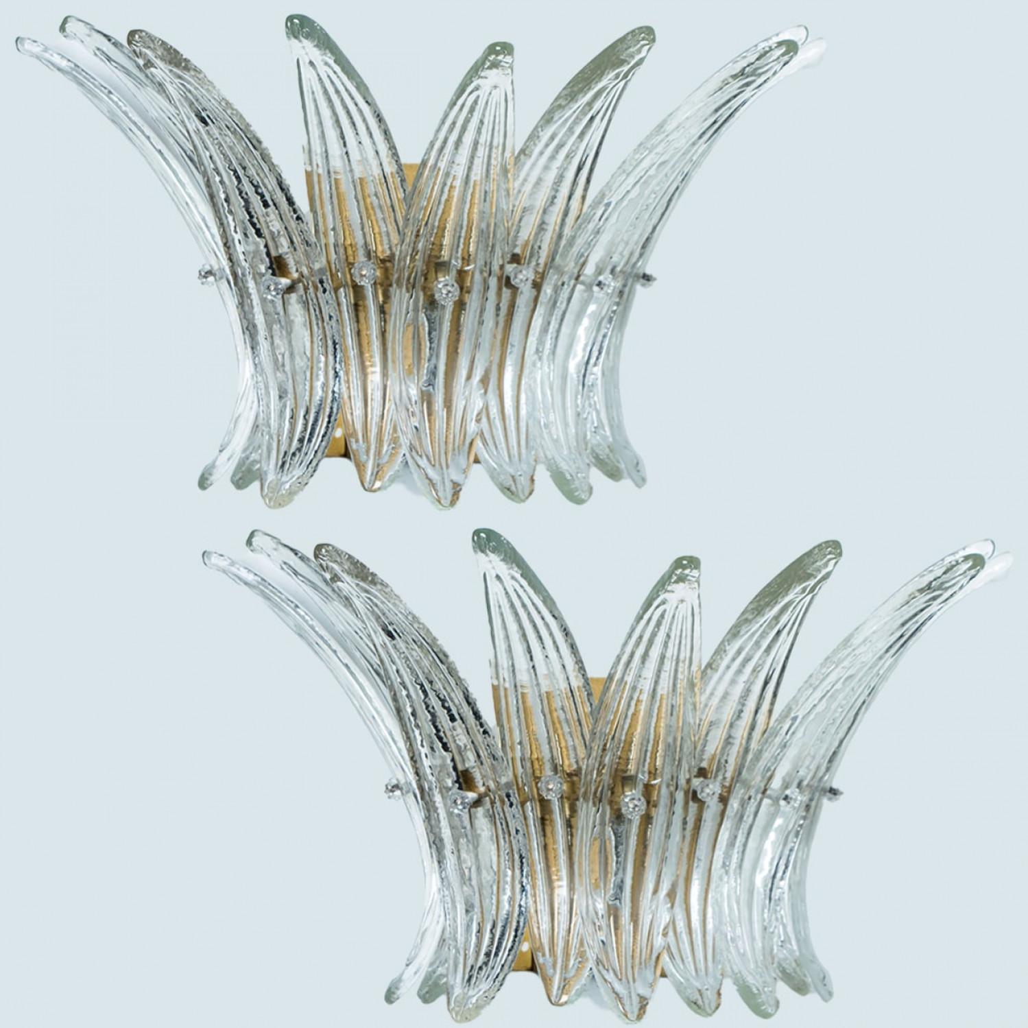 Beautiful wall lights were designed in the style of Kalmar, featuring a brass base and a rectangular glass cover in opal and clear glass. The glass cover consists of one layer of beautiful palm leaves put together to create a 