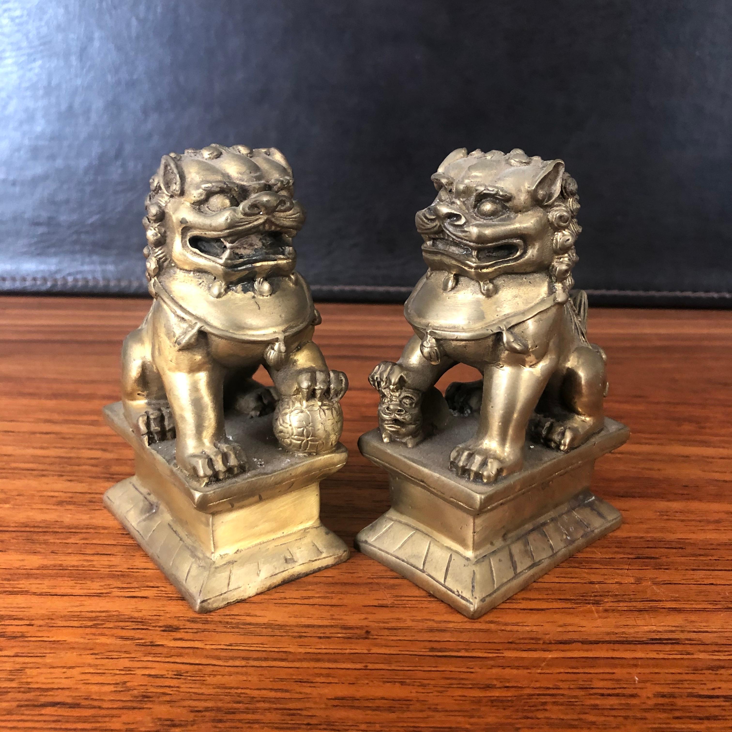 Pair of small patinated bronze Chinese foo dogs, circa 1950s. Excellent vintage condition with amazing detail and a gorgeous patina. Each dog measures 4.25