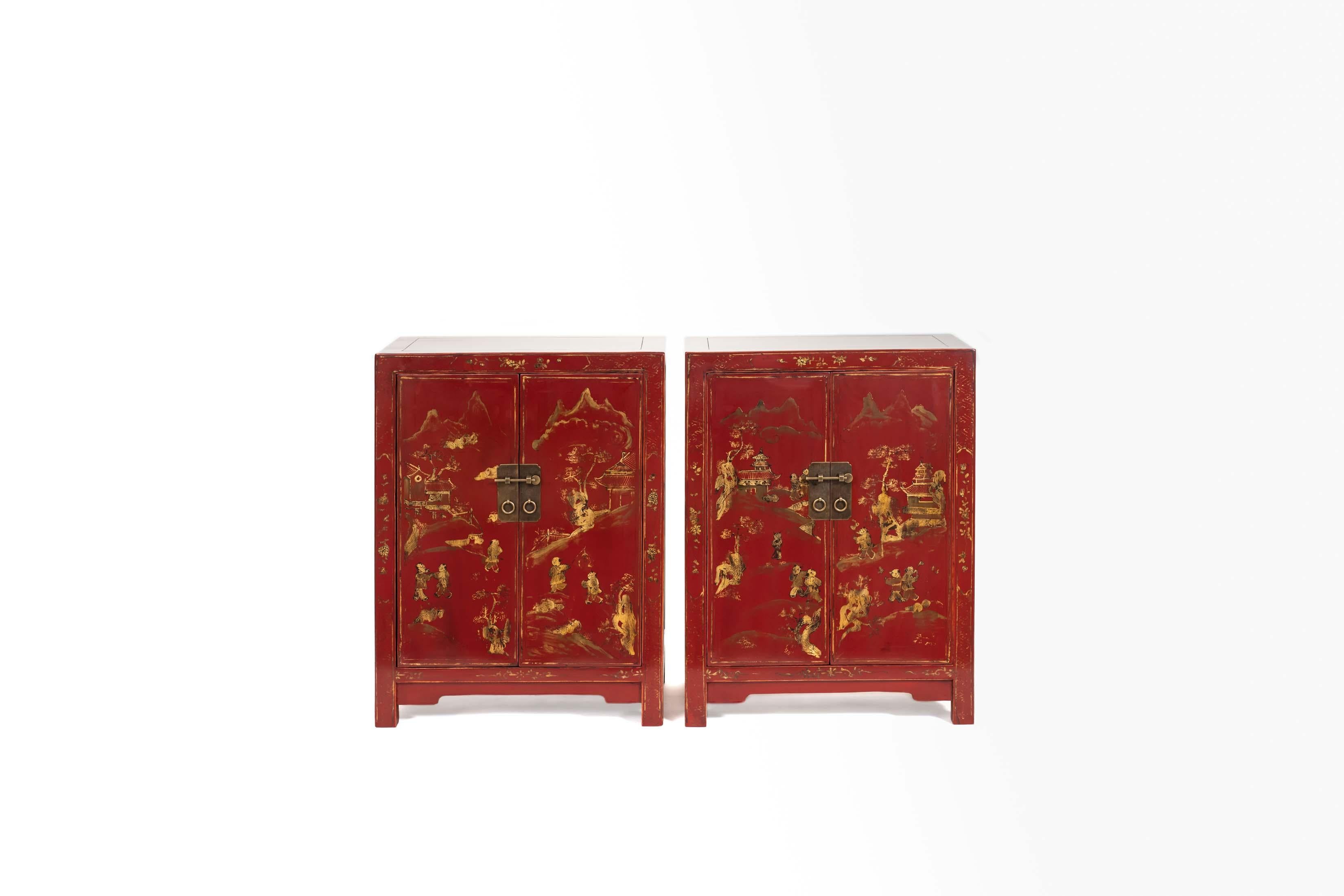 The square corner cabinets with rectangular-sectioned frames, a pair of flushed paneled doors with gilt hand-painting of children at play in the courtyard, opening to the interior with A mid-shelf, the legs continuing to form the feet, braced by