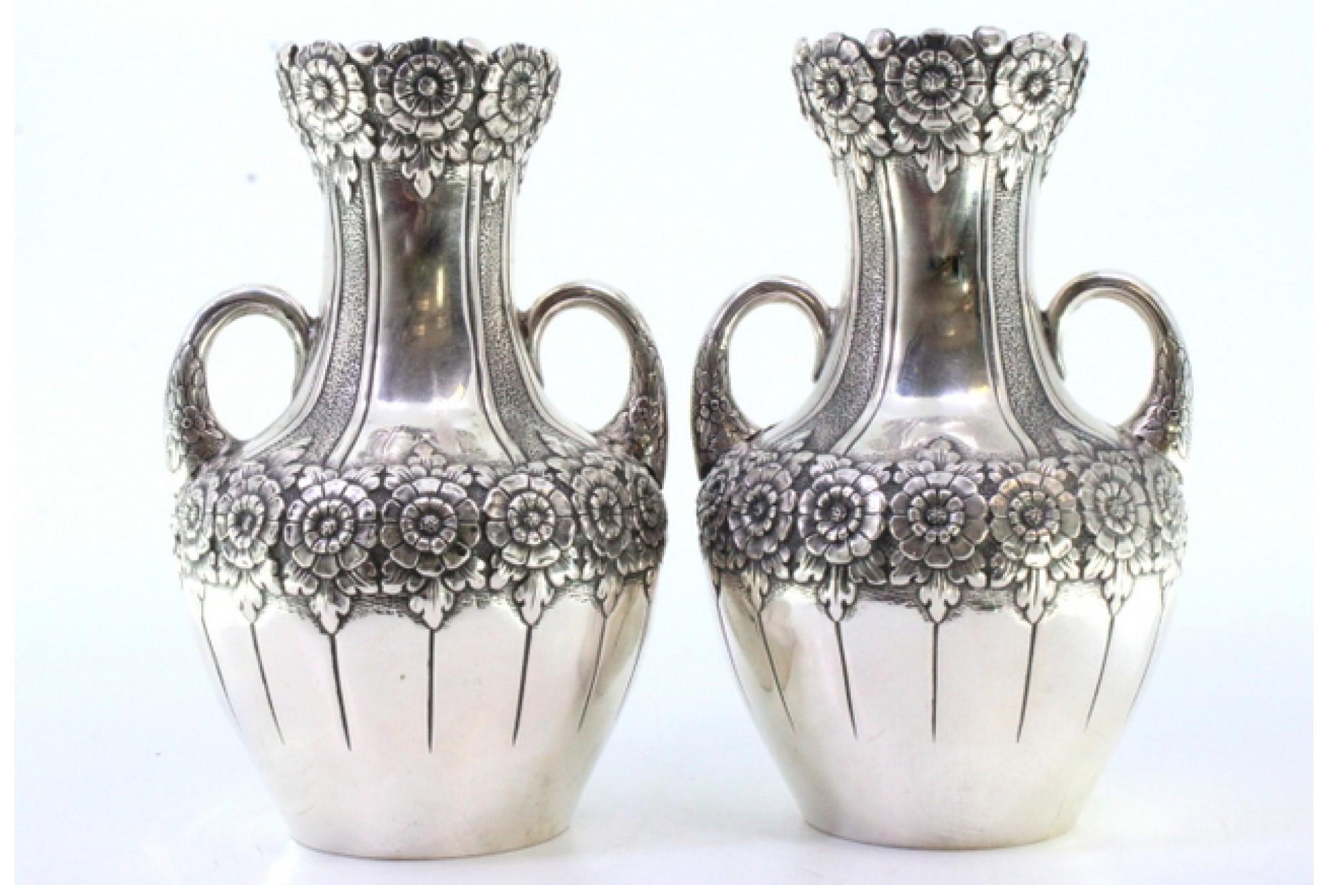 Description: Set of a pair of small silver jugs with floral motifs and raised garlands with two handles. Metal: Silver. Origin: Portuguese. Brand: javali II Title. Weight: 370.92 grams (Set of jugs). Dimensions: 9.5cmx14.5cm. Content: 833/1000.