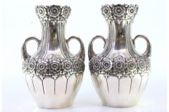 Pair of small silver jugs with floral motifs and embossed garlands