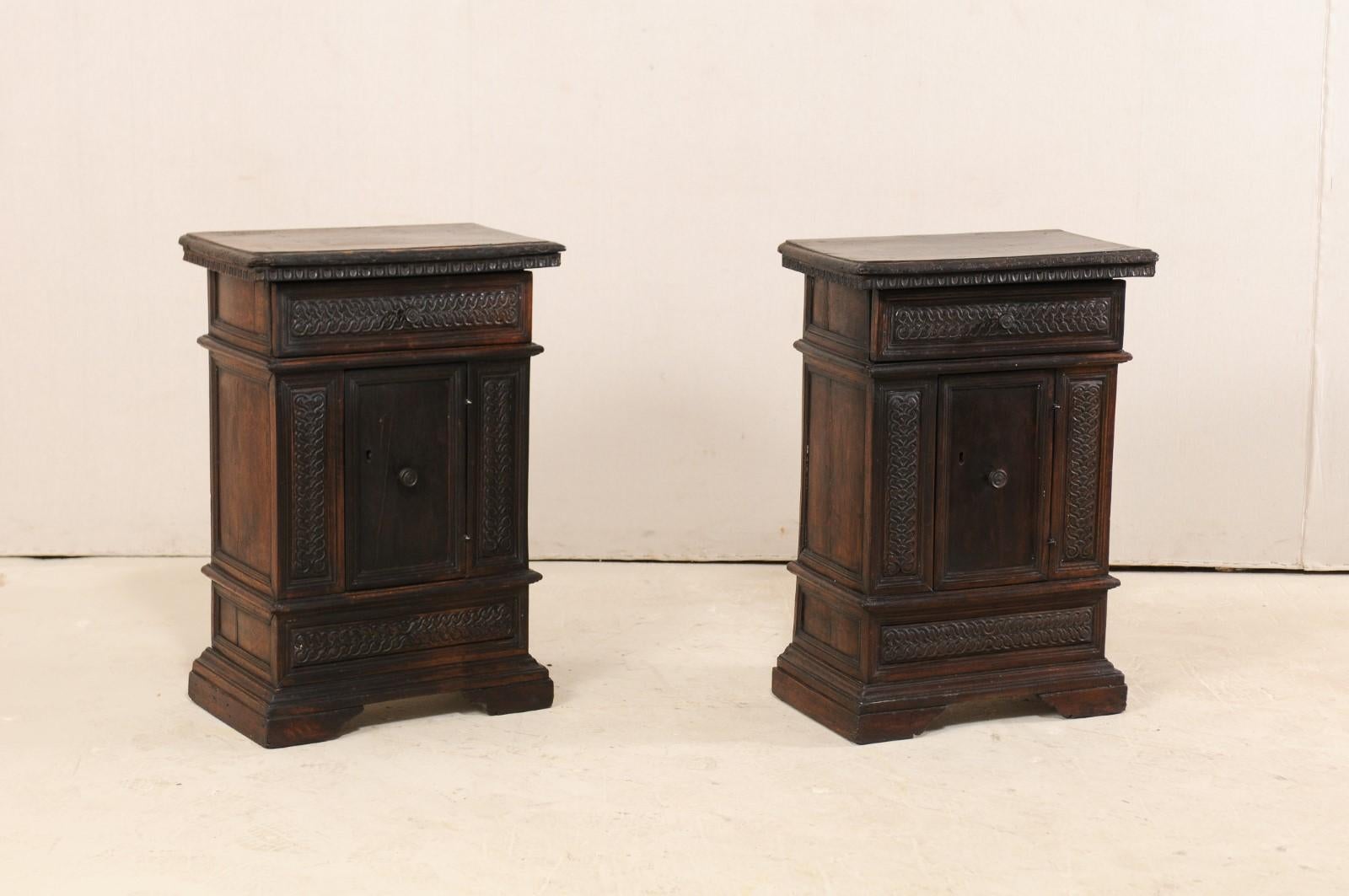 A pair of small-sized Italian walnut wood side chests from the 18th century. These antique cabinets from Italy have rectangular-shaped tops, with hand carved egg-and-dart trim along their undersides, which rests atop their cases each adorn in