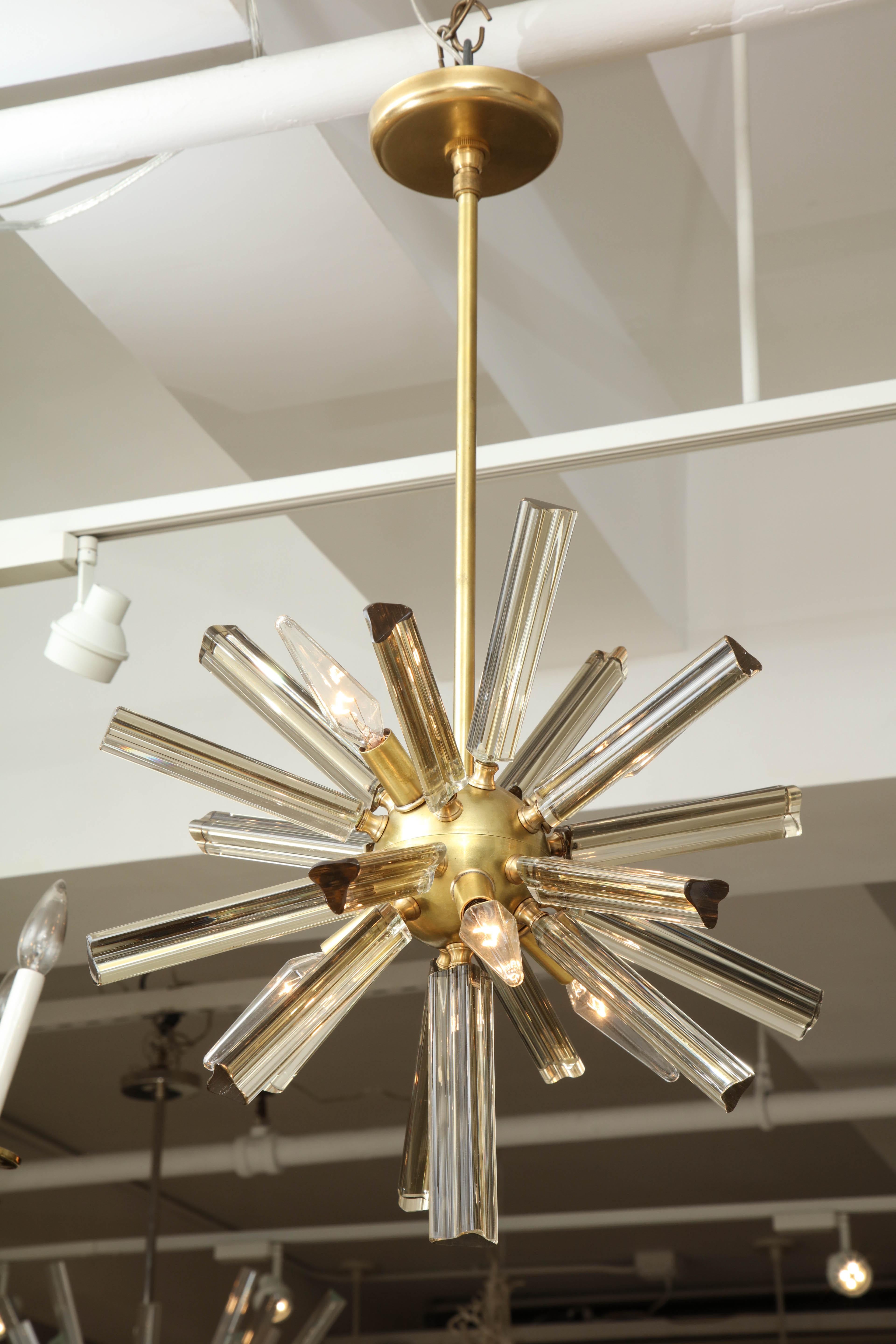 A pair of small Sputnik chandeliers with a brass frame and slightly smoky glass. Re-wired for use in the U.S. and ready to hang.