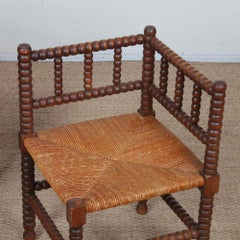 Pair of small straw-seated corner chairs in turned wood, 1940