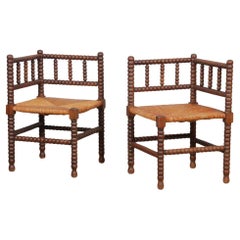 Pair of small straw-seated corner chairs in turned wood, 1940
