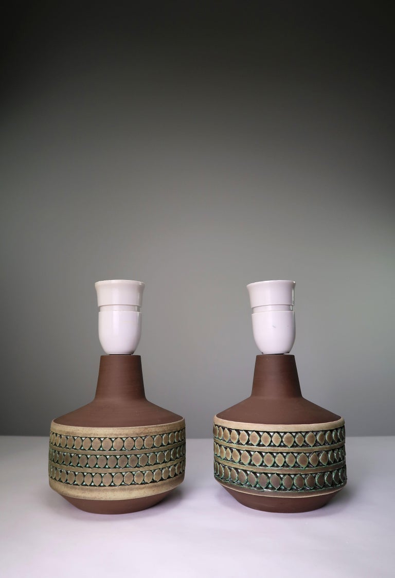 Set of two small Scandinavian Mid-Century Modern handmade ceramic table lamps by acclaimed ceramic artist and writer Tomas Anagrius from Stockholm (1939-). Manufactured in the small Swedish town of Kvidinge in the late 1960s. Raw neck and base with