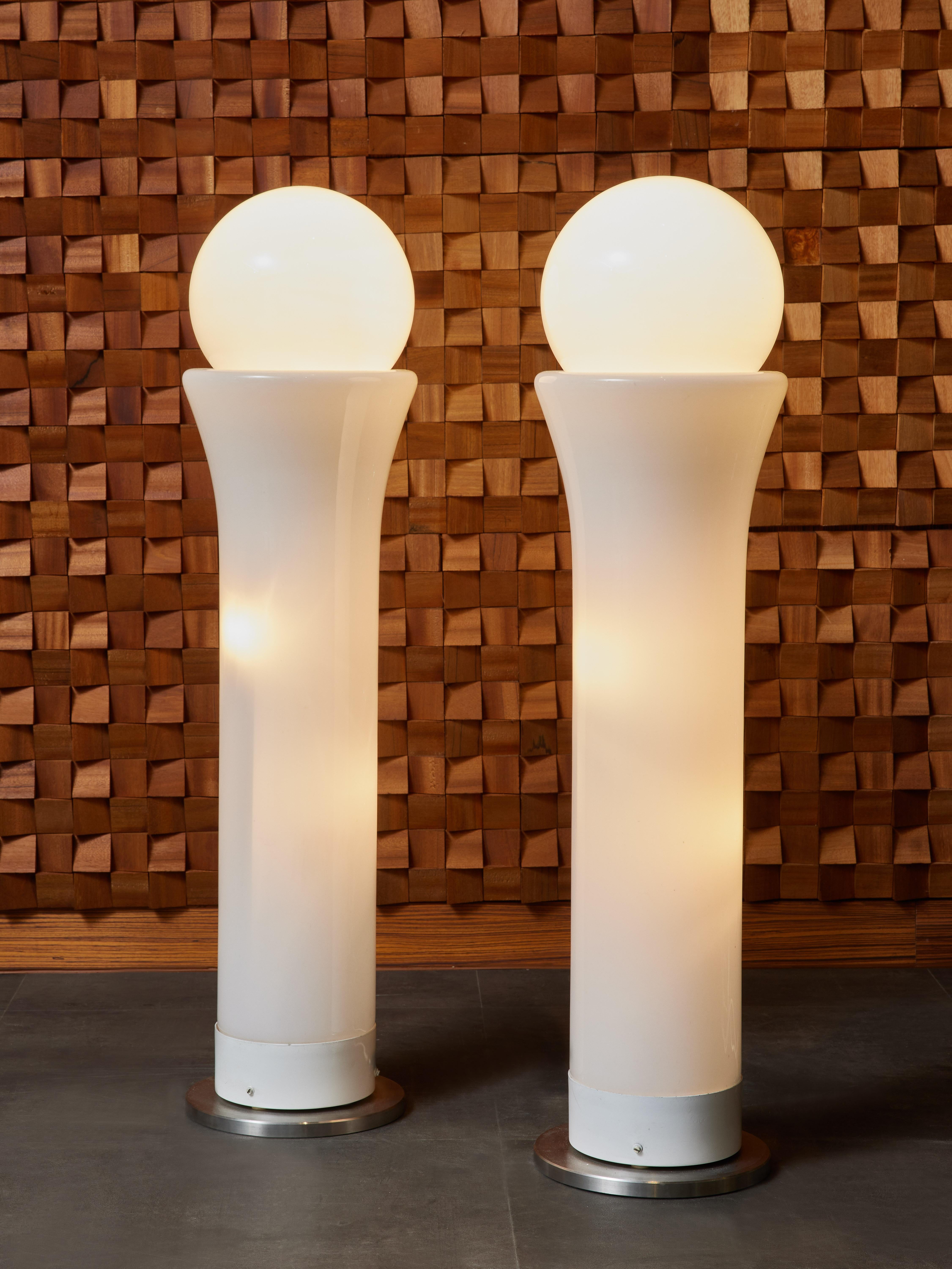 Pair of vintage floor lamps designed by Vistosi, made of an aluminum and opaline glass.
There several sources of lights, in the main body and in the top globe, fitted in the top of the vertical structure. 

