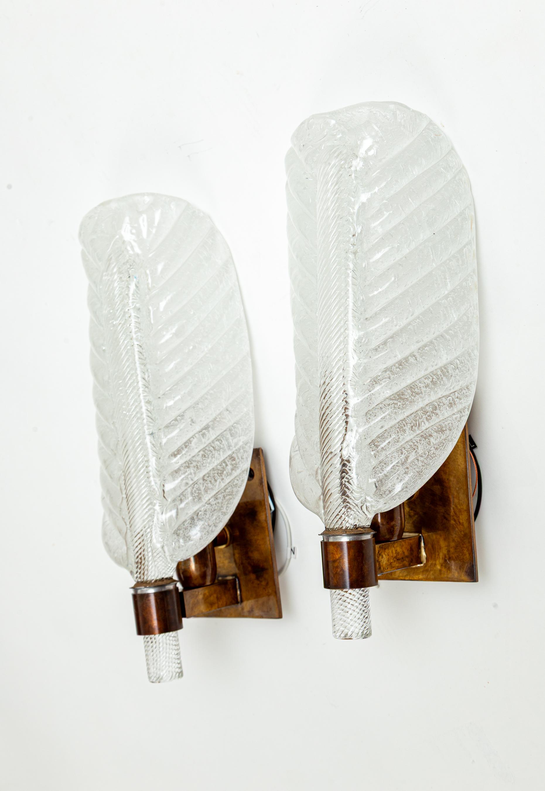 Un affascinante vetro soffiato artigianale a forma di foglia con un gambo centrale trasparente e tortuoso. Nota che la parte della foglia del vetro è soffiata con una minima quantità di bianco per creare un'illuminazione opaca in cui non si notano