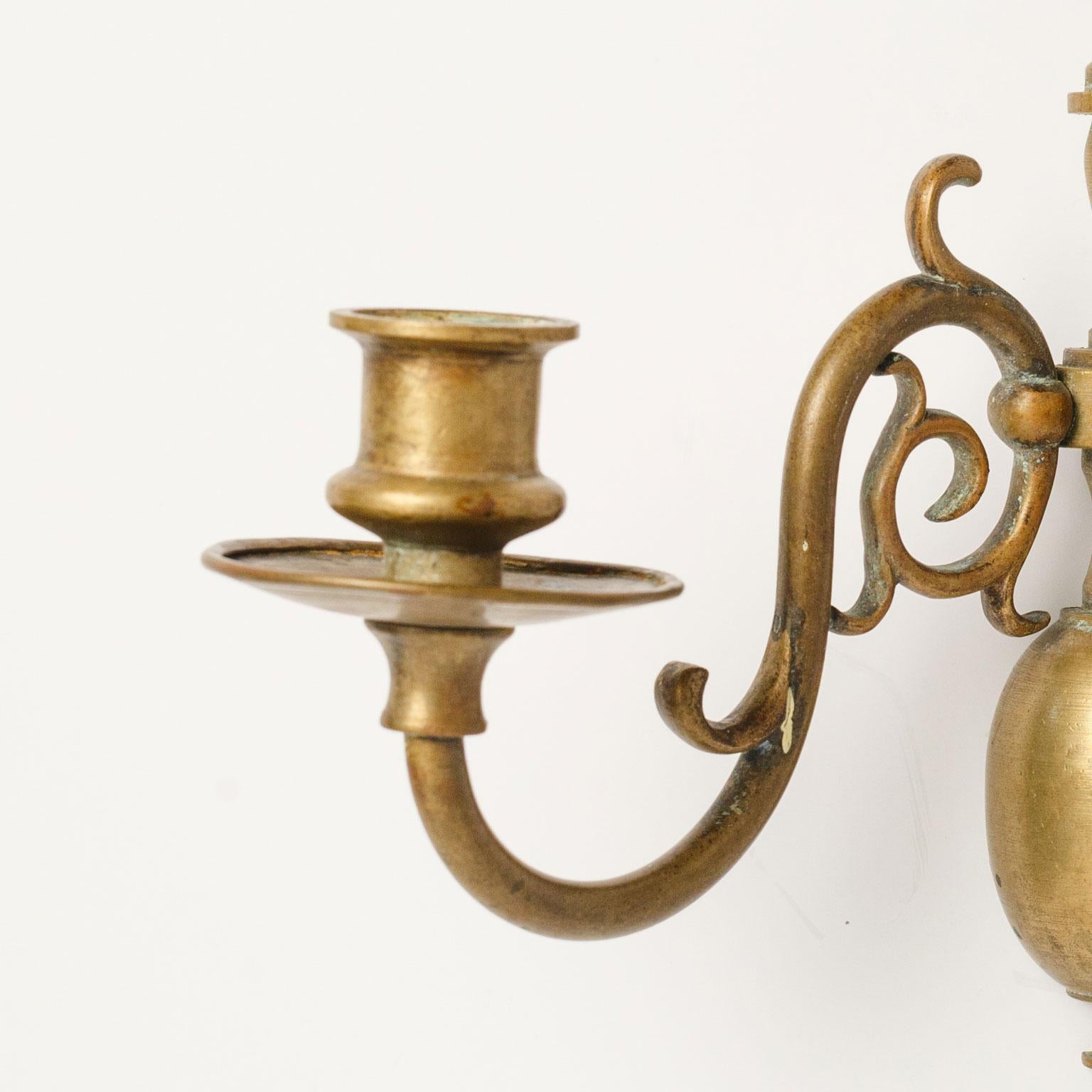 Pair of smaller-scale brass sconces with two arms each. Vintage lights in Flemish (or Dutch) style. Unwired, but can be wired for electricity for an additional cost. Sold together as a pair for $850.