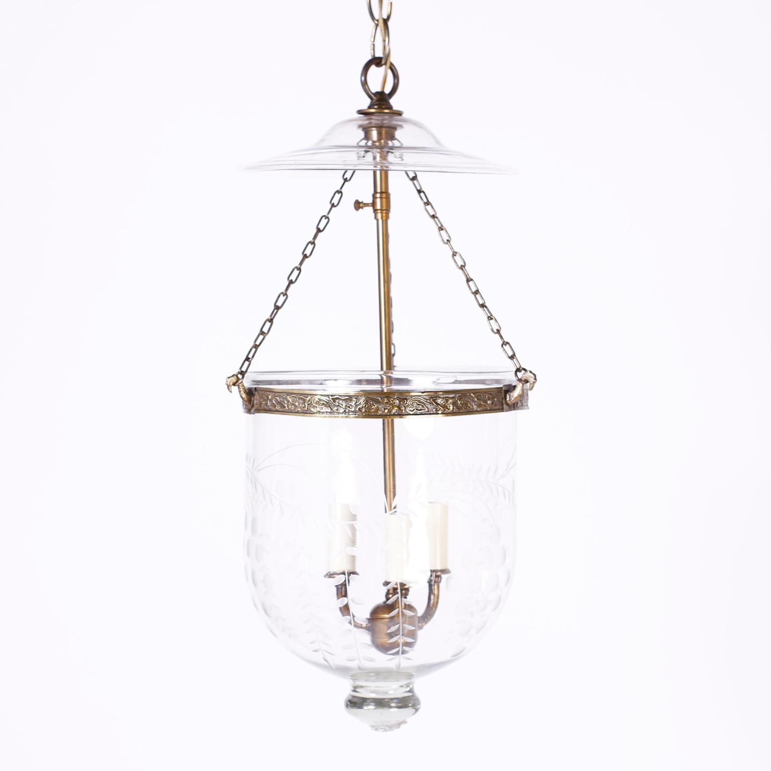 Antique pair of English bell jar pendant light fixtures or lanterns with classic form, smoke bell, brass hardware with adjustable stem and a hand blown glass bell with etched leaves and berries. Priced individually.