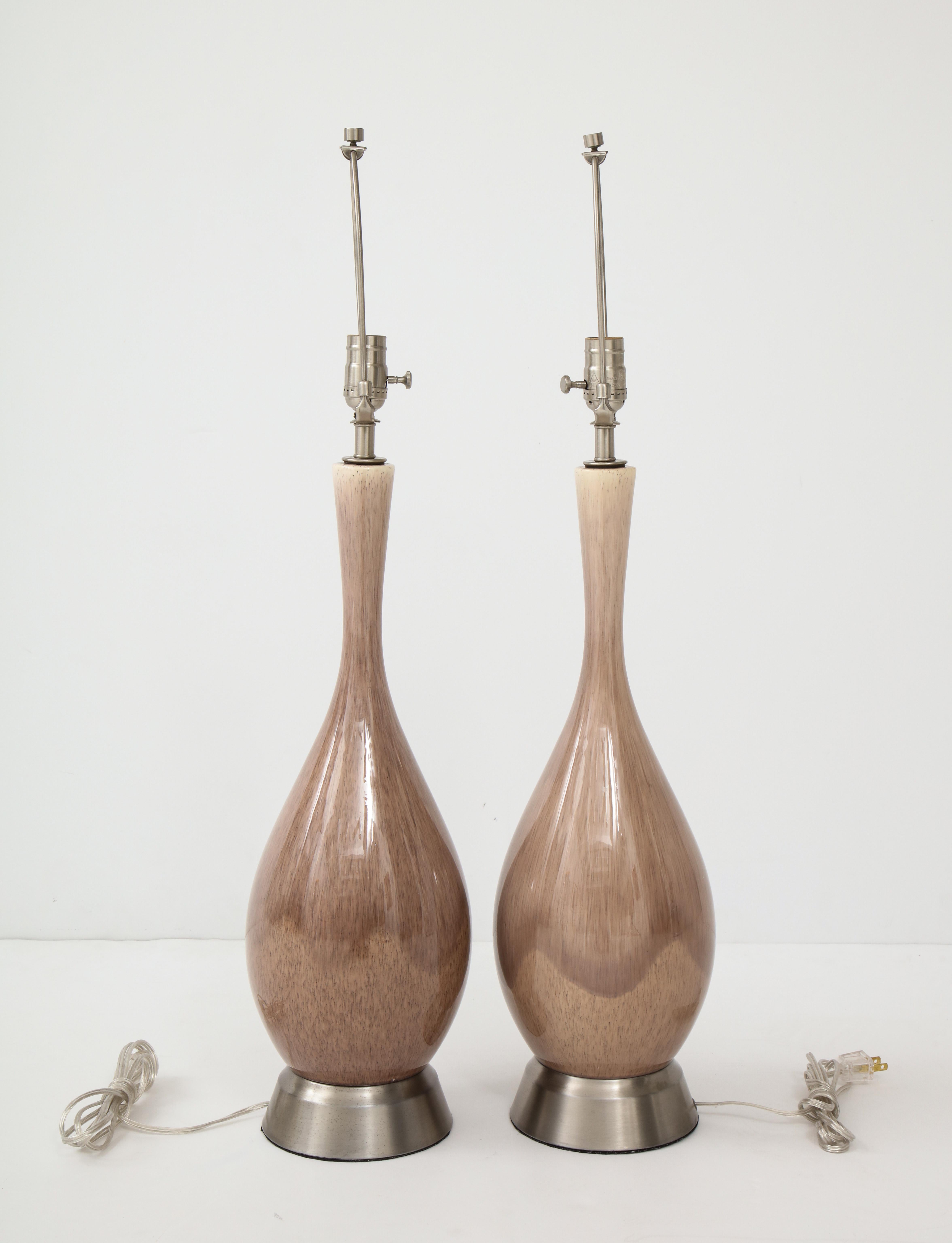 Pair of midcentury bottle form ceramic lamps with a seductive smokey amethyst/grey glaze resting on brushed nickel bases. Rewired for use in the USA.
100W bulb max. On display at 200 Lexington Avenue, 10th floor.