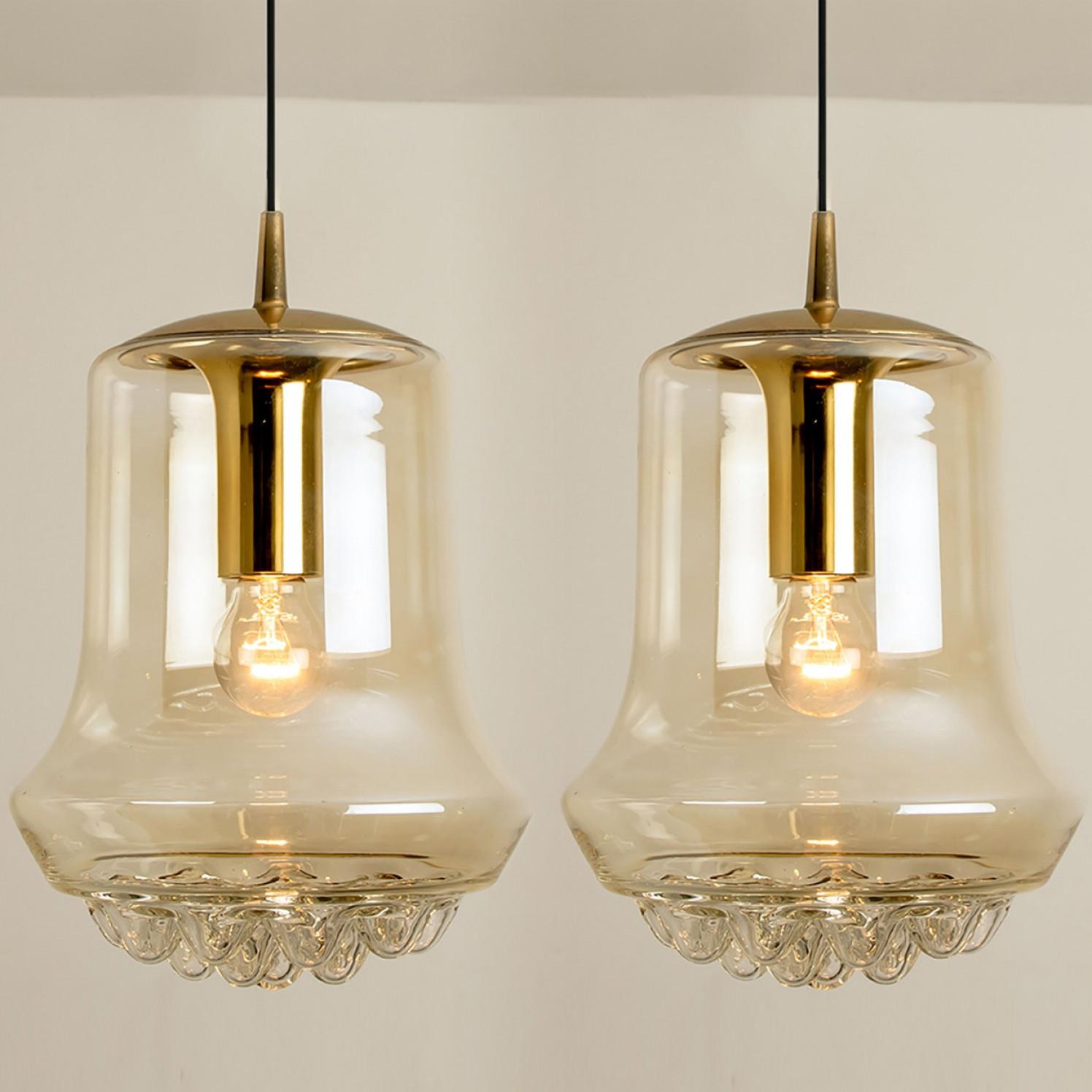 Pair of smoked golden/brown pendant lights, 1960s by Peill and Putzler in Germany, Europe. A unique shape and a wonderful light effect due to lovely glass elements. High quality pieces. Illuminates beautiful. True craftsmanship of the 20th