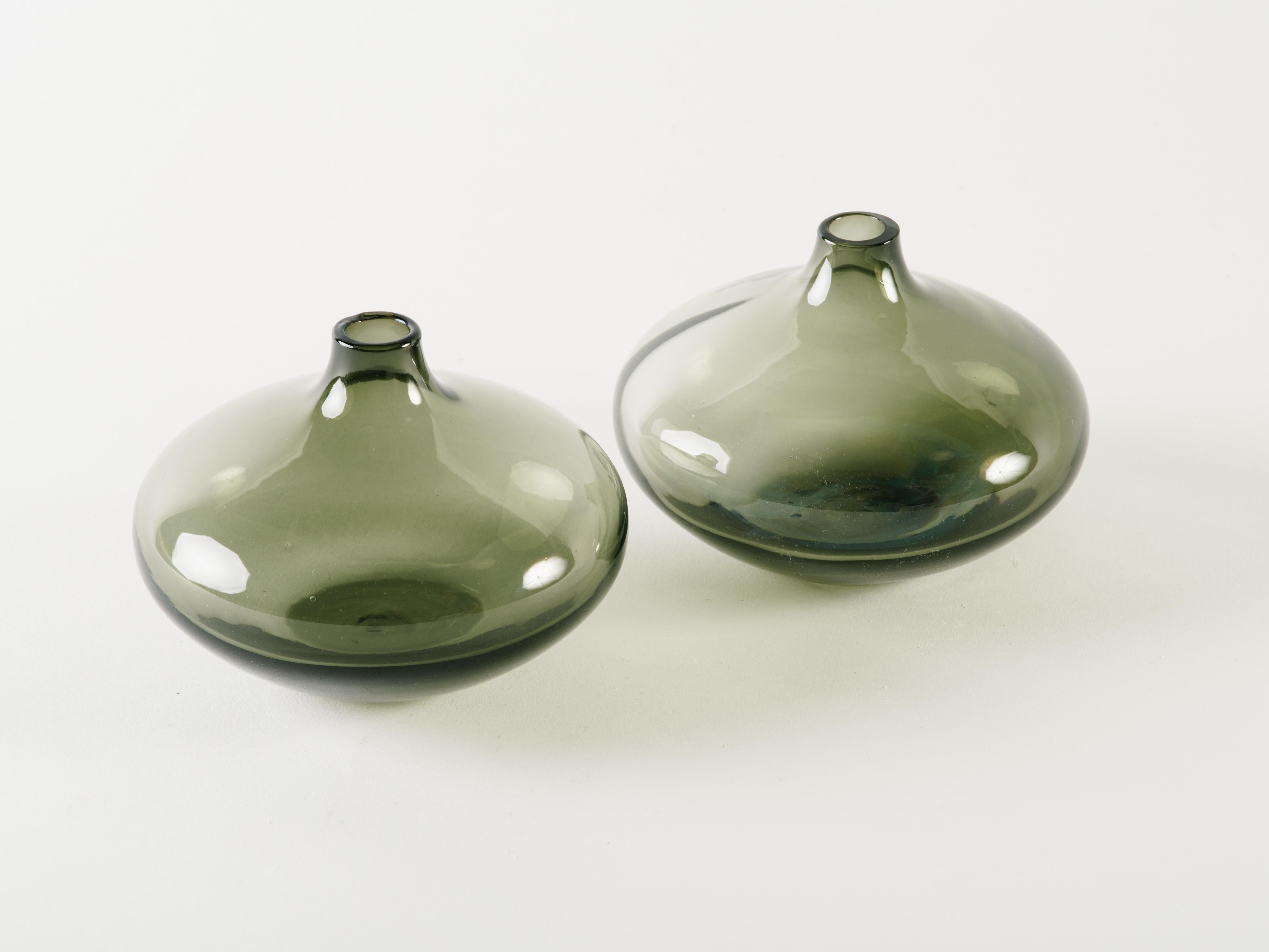 Pair of Mid-Century Modern blown glass vases in hues of smoked grey or translucent black. Bud vases have elegant teardrop forms, reminiscent of small genie bottles. Small vessel opening perfect for single stem flowers.