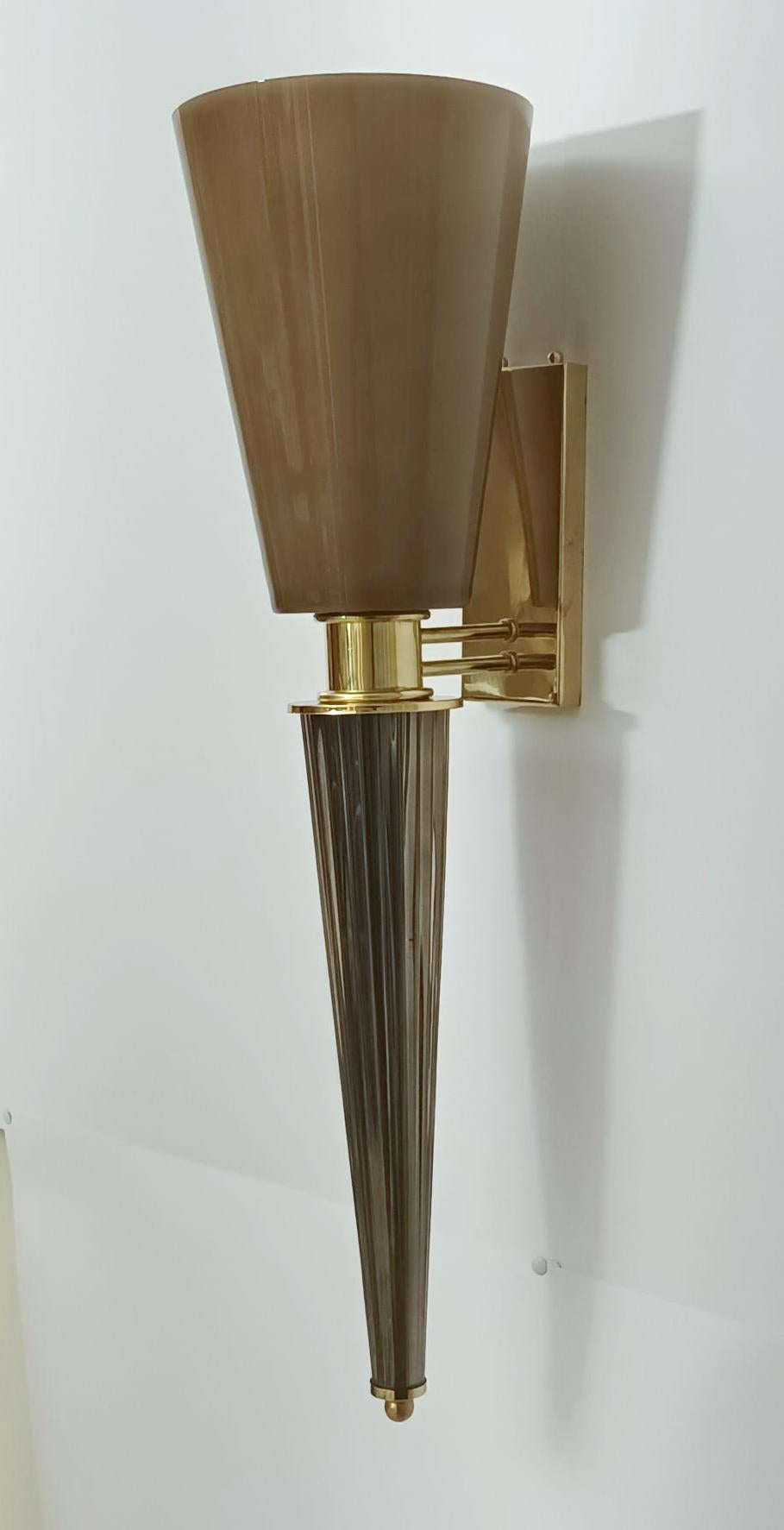Appliques murales italiennes en forme de torche avec des abat-jour coniques en verre de Murano brun fumé soufflé à la main, montés sur des cadres en laiton / Fabriquées en Italie.
1 lampe / type E26 ou E27 / max 60W
Mesures : hauteur 29.5 pouces,