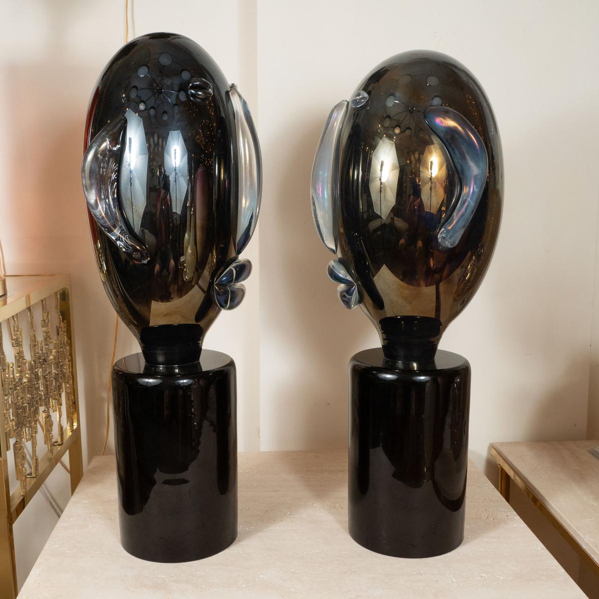Pair of smoky glass head sculptures.