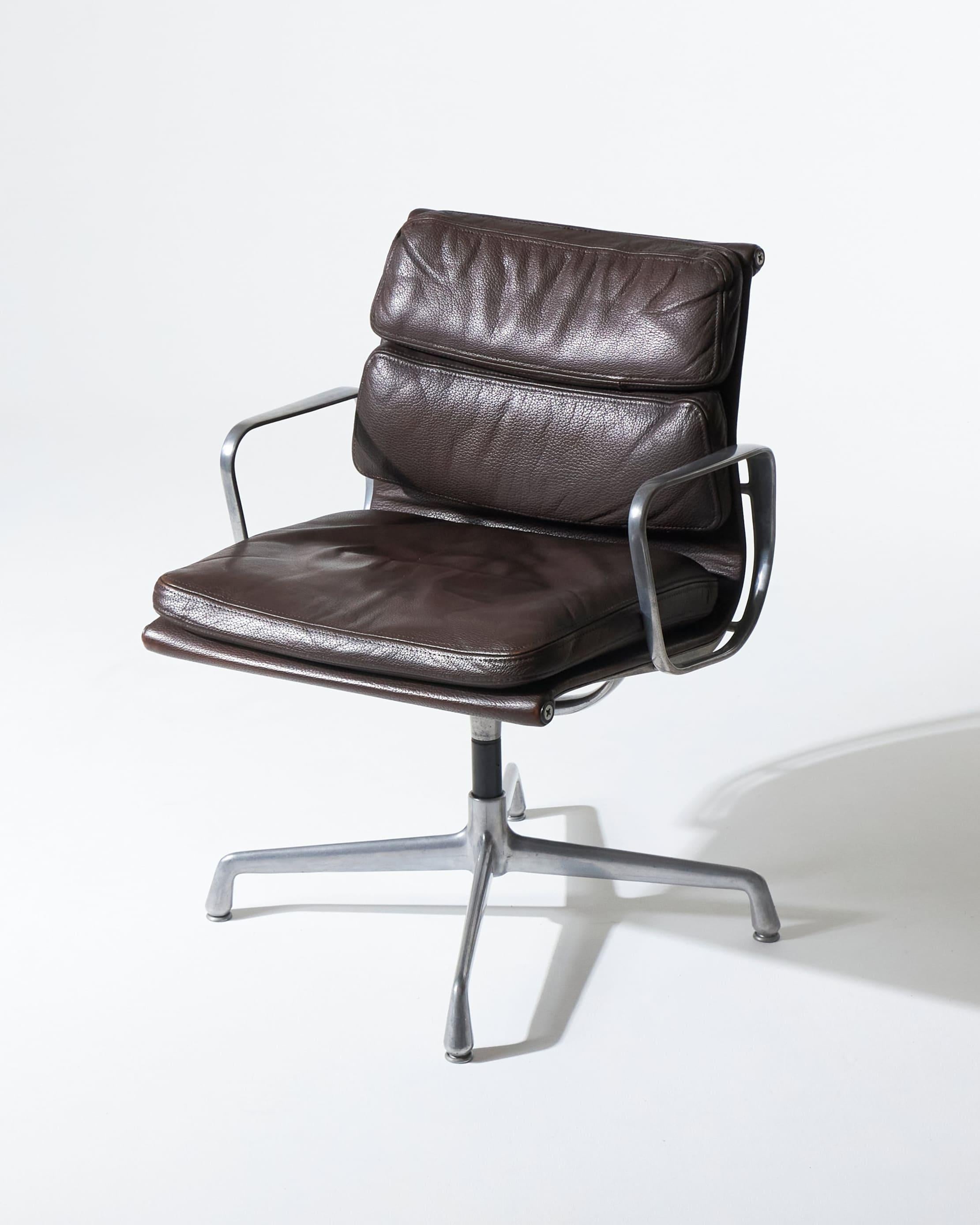 Coppia di poltrone Soft Pad EA 208, disegnate da Charles e Ray Eames (1969), edite da Herman Miller. Struttura in alluminio con seduta e schienale in pelle marrone. Un modello iconico degli anni '70 che unisce comfort ed eleganza. Ideali come sedie