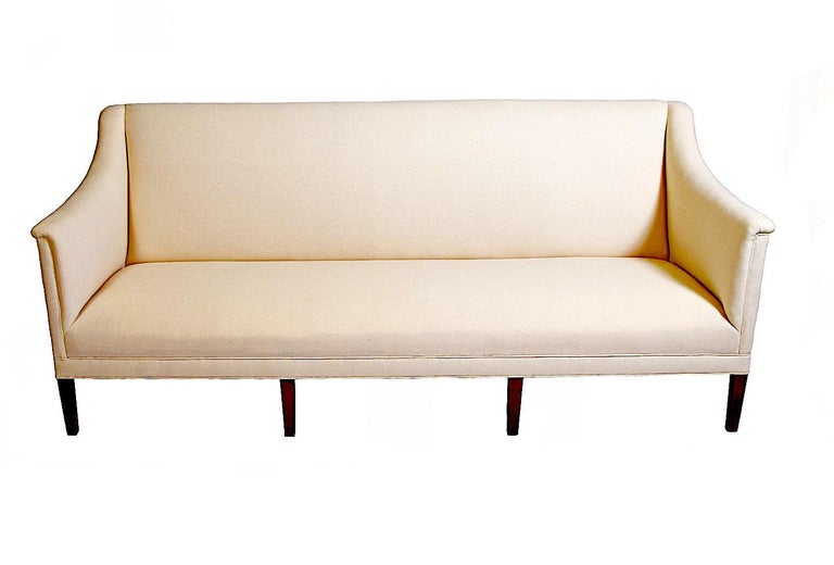 Pair of beautiful sofas by Kaare Klint, one of the foremost designers of early Danish modern.. Newly reupholstered in off-white. Elegant neo-classical lines make for very comfortable seating. One of Kaare Klint's earliest designs was in 1922 and is