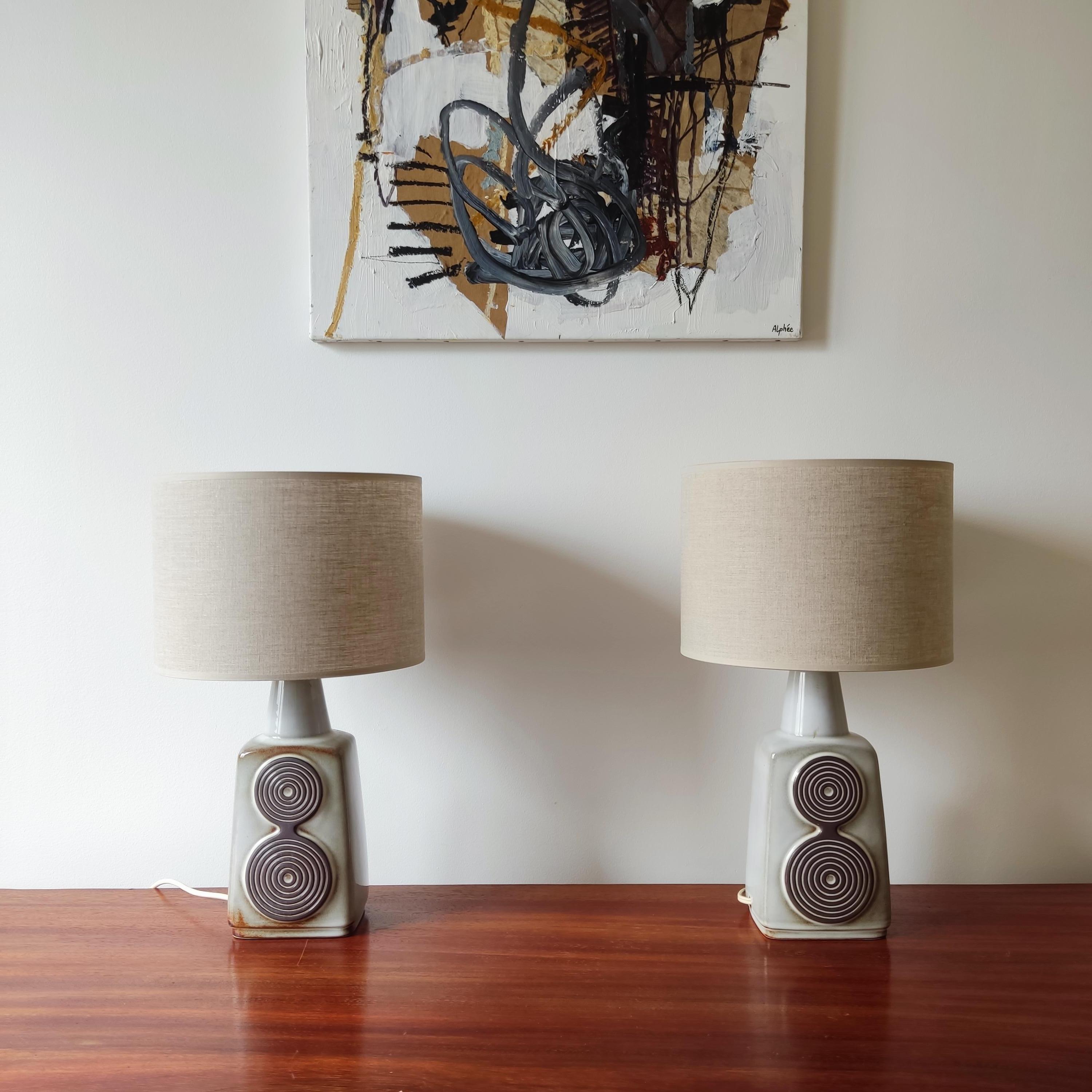 Paire de lampes en céramique Soholm Stentoj - Danemark, années 1960

Chaque lampe est émaillée en gris clair et décorée de motifs circulaires en relief brun foncé.
Chaque pièce est unique, ce qui explique les légères variations de glaçure d'une