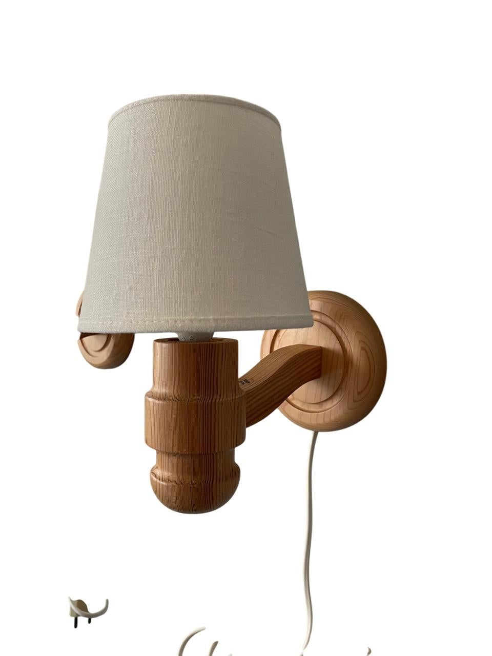 Ein schönes Paar Wandlampen von Solbackens Svarveri aus massivem Kiefernholz, das klassisches skandinavisches Design aus den 1970er Jahren präsentiert. Die Lampen kombinieren natürliche MATERIALIEN mit sanft gedrechselten Holzelementen, wodurch ein