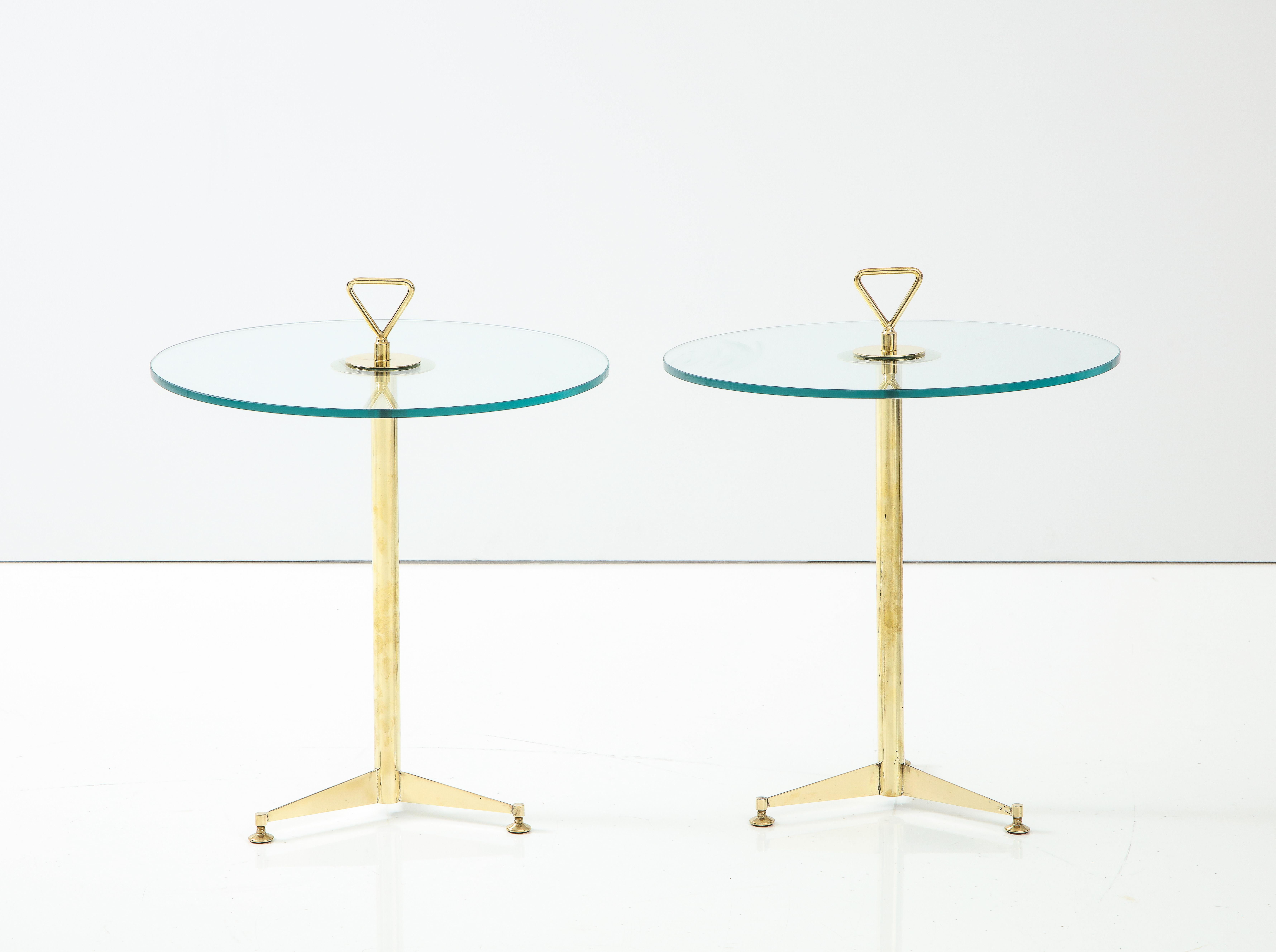 Pair of Italian brass martini side tables with clear round glass tops. Tripod brass base and with brass handle. Handcrafted in Italy of solid brass. Minimalist and clean lines. Overall height of table, including handle is 22.5