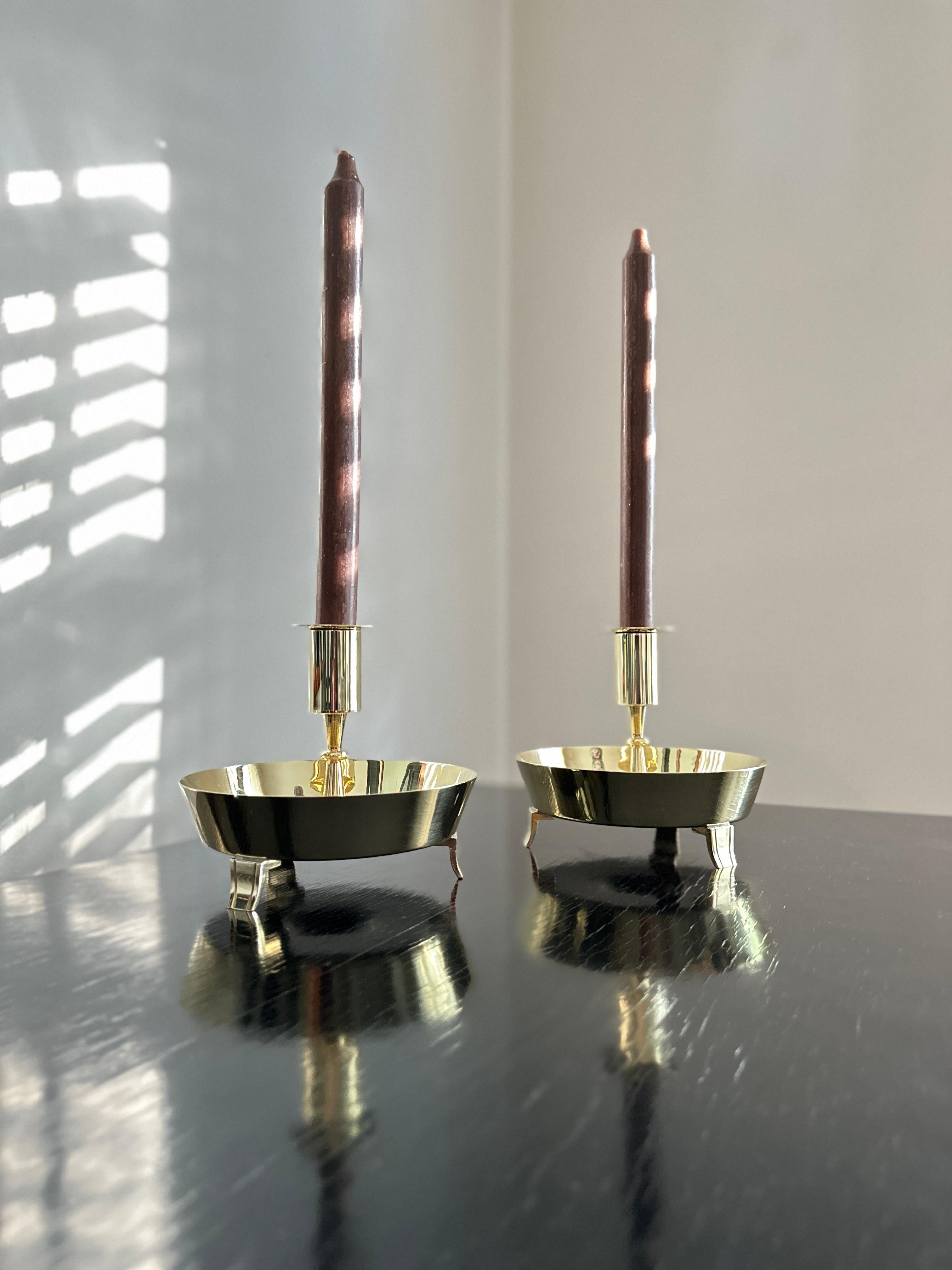 An obscure design by Tommi Parzinger for Dorlyn Silversmiths. A pair of vintage solid brass candlesticks with removable bobeche's listed in the Dorlyn Silversmiths catalog as 