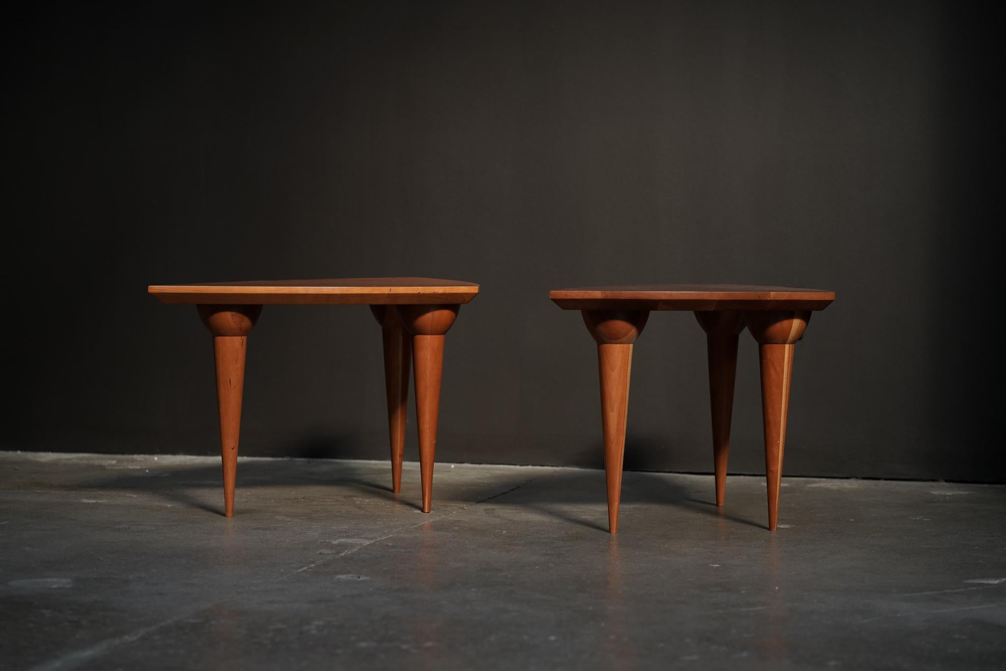 Fabriquée en Californie dans les années 1990, cette paire de tables d'appoint en bois de cerisier présente des pieds sculpturaux et une finition naturelle et chaleureuse. Un mélange de design réfléchi et d'artisanat intemporel, parfait pour donner