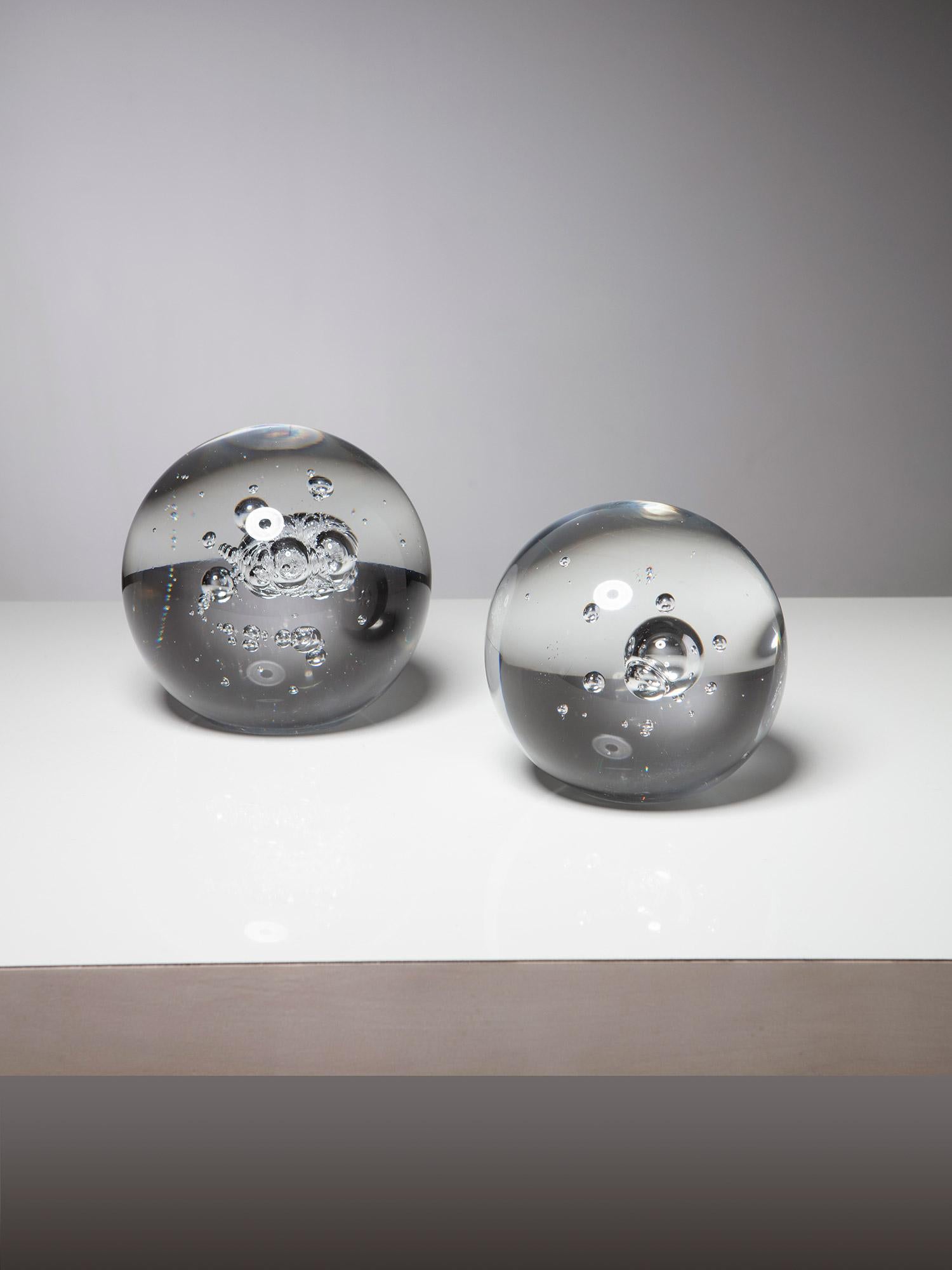 70s glass spheres with air inclusions.
A small grinding on the bottom provide stability of the heavy pieces.