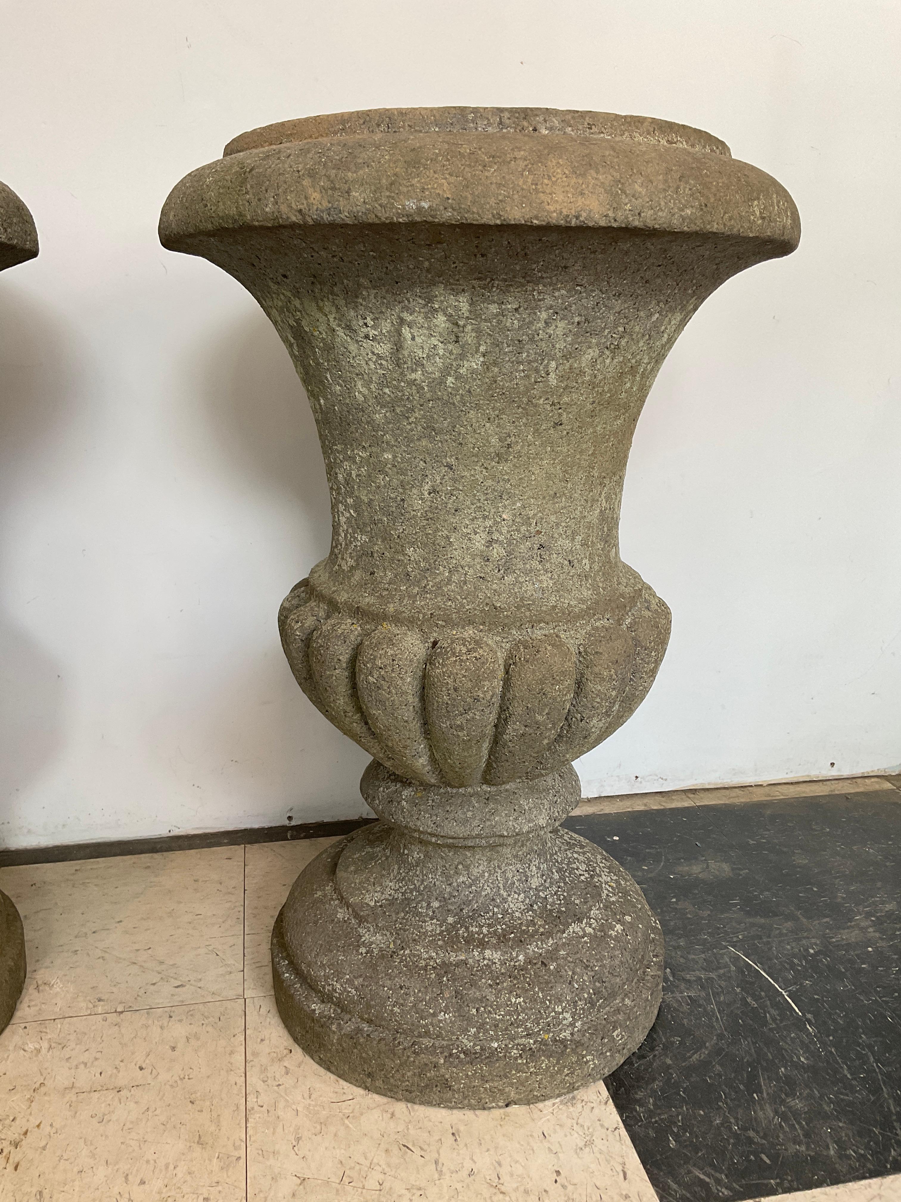 Pair of tall granite urns, carved from one piece of solid stone. Unpolished. They are heavy! The depth of the inside opening is 7.5”. Diameter of opening is 12”.