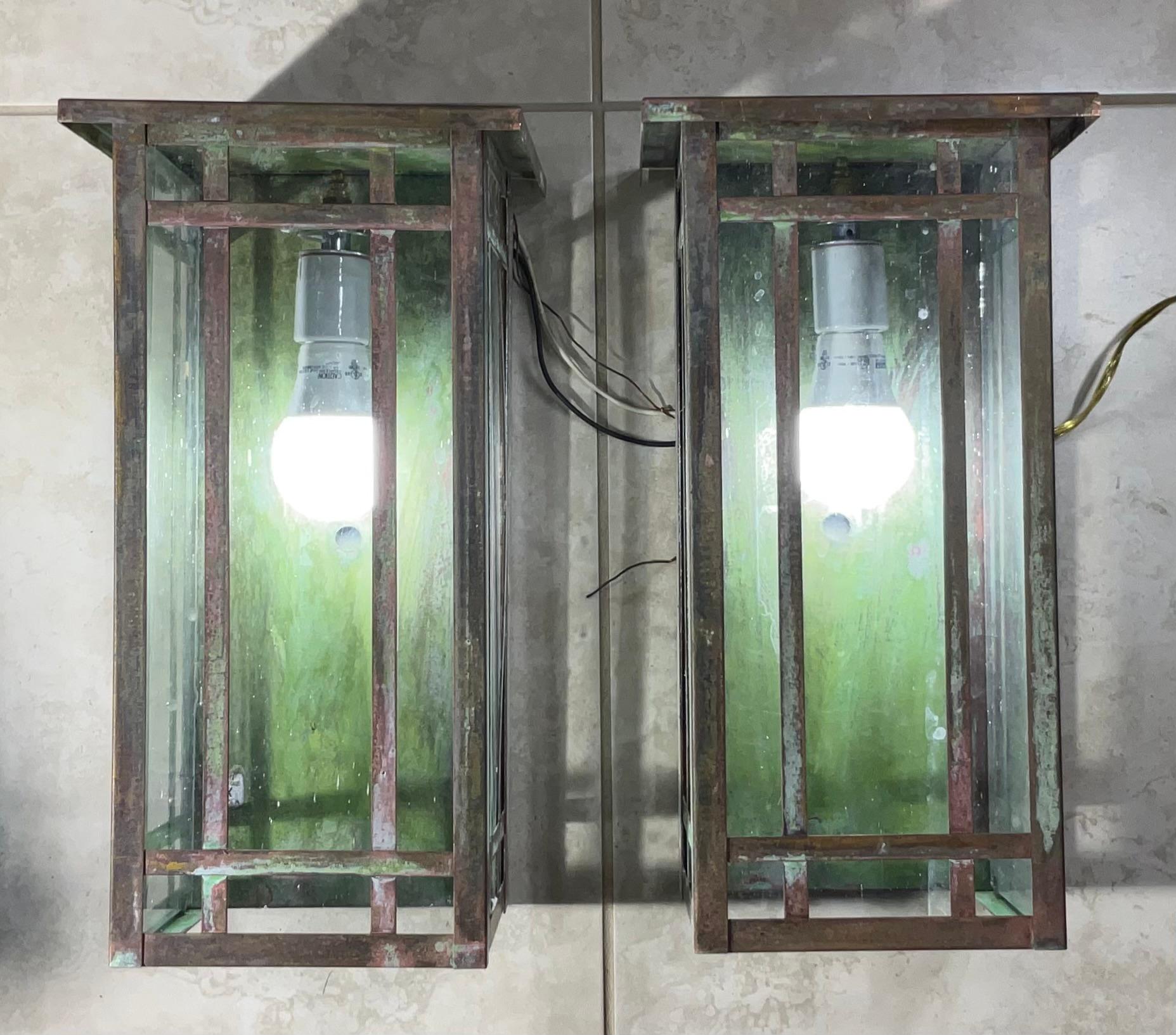 Illuminate your home with this exquisite pair of solid brass wall lantern sconces, embodying the enduring charm of the Arts & Crafts movement. These substantial and beautifully crafted lanterns offer a touch of vintage sophistication and a warm,