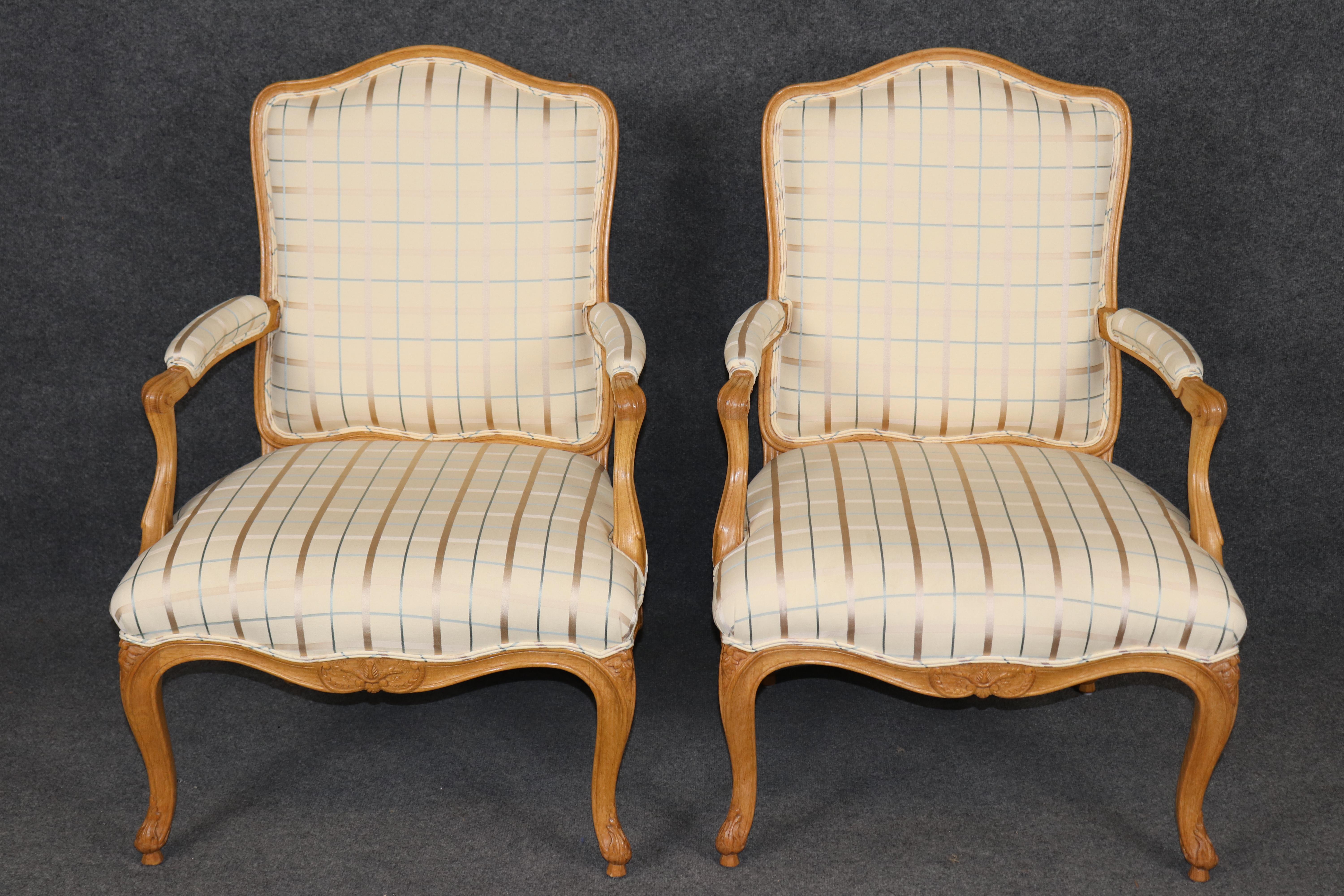 Questa è una bellissima e sofisticata coppia di poltrone Luigi XV. Realizzati in rovere, sono formali e molto sofisticati grazie alla loro tonalità più chiara. La tappezzeria è in buone condizioni e può presentare alcuni piccoli segni dell'età e