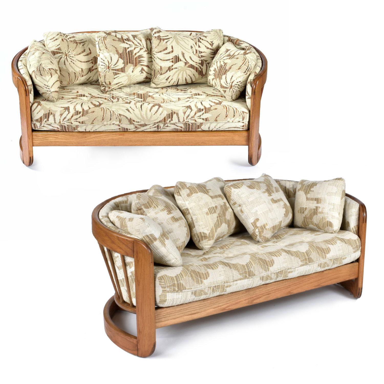 Pair of curved, solid oak loveseat sofas by Howard Furniture. The curved shape make these two loveseats ideal for placement as a pair. The crescent shape and ample cushions create a cozy, intimate seating arrangement. Solid oak throughout with