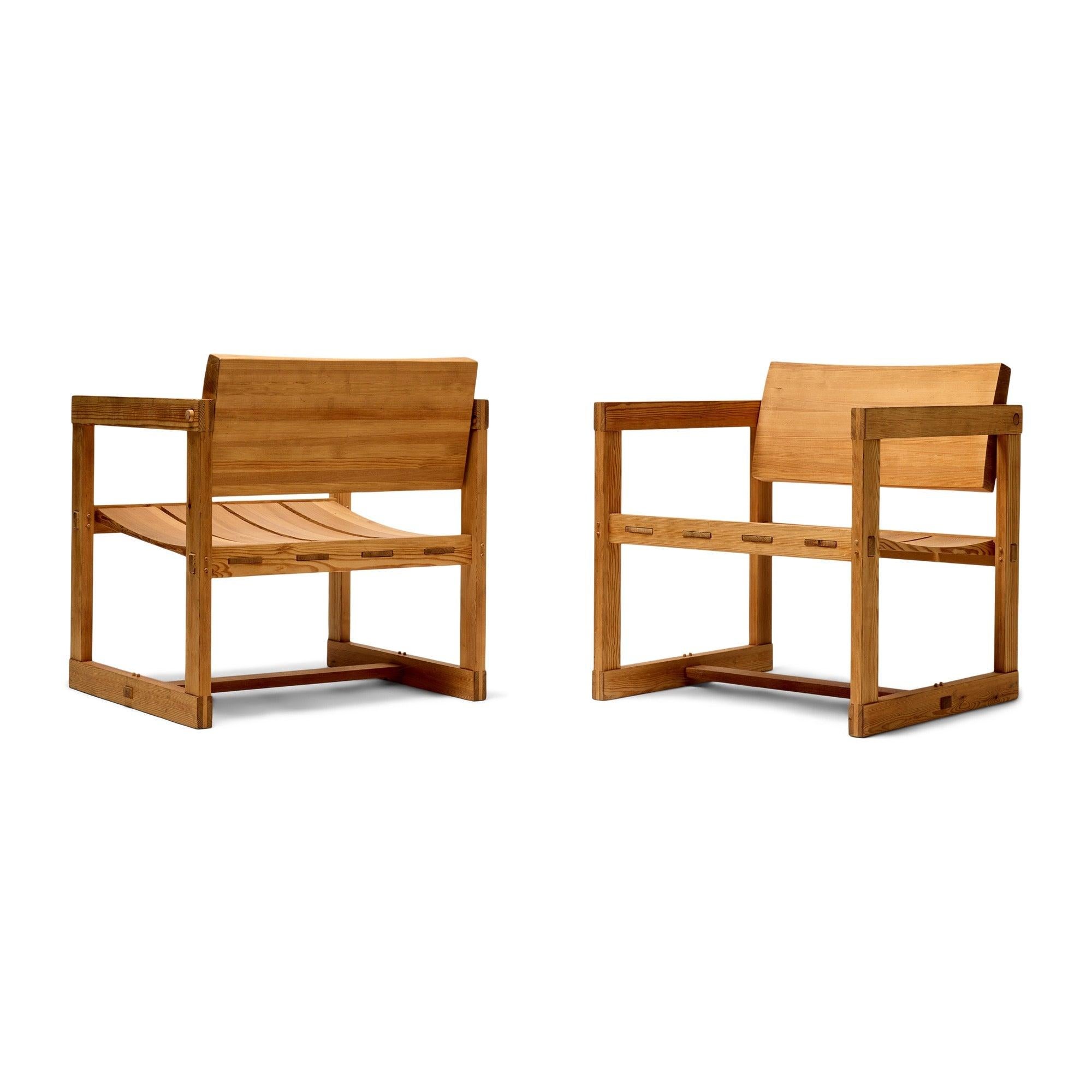 Paire de chaises de salon architecturales en pin avec dossier pivotant et menuiserie apparente.