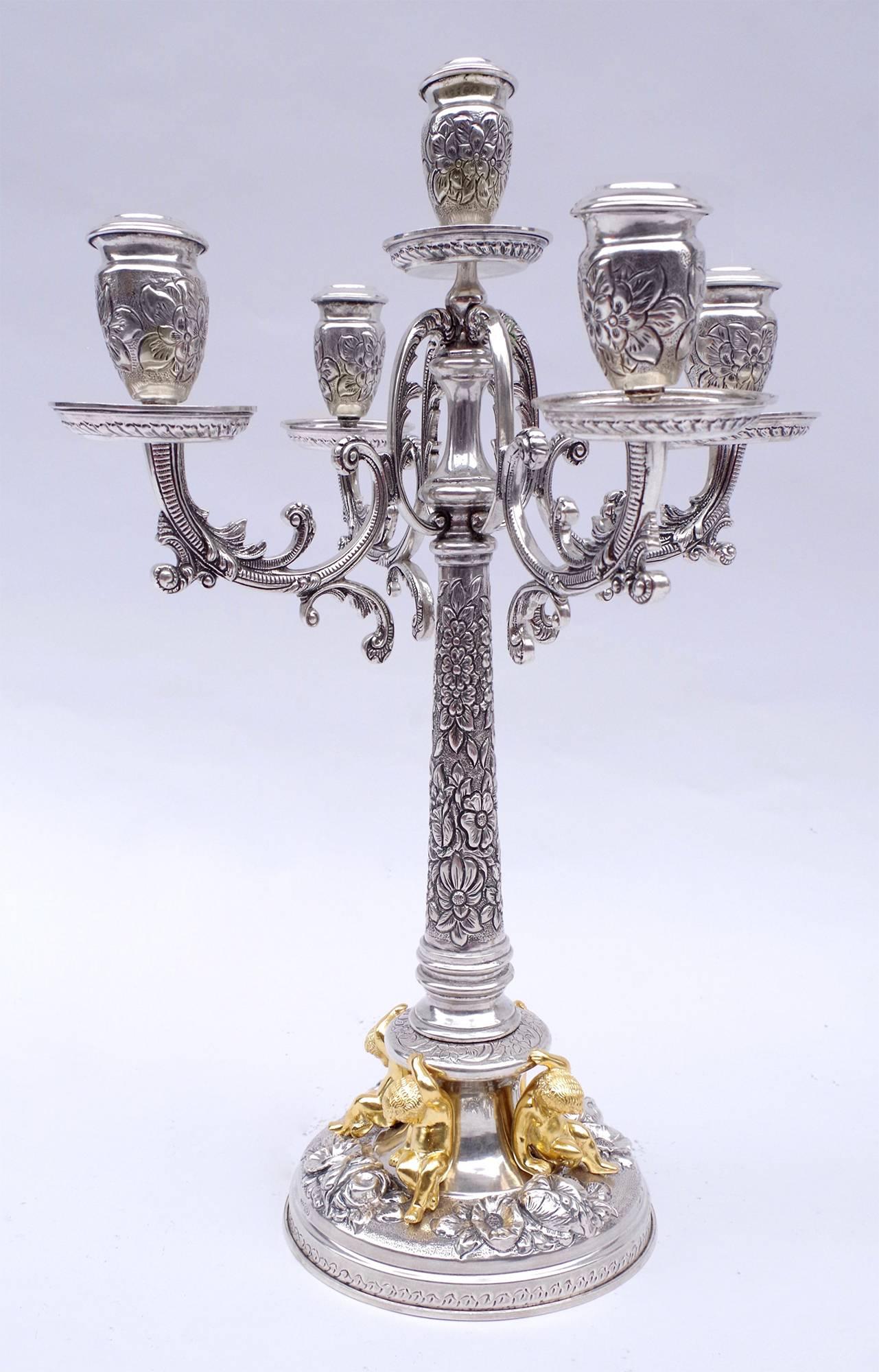 Pair of candelabra with four arms and five fires in the Louis XIV style in solid silver chiseled with interlaces patterns.

Arms are adorned with stylized vegetals and four gilt putti decorate the round base of each candelabrum.

Spanish work
