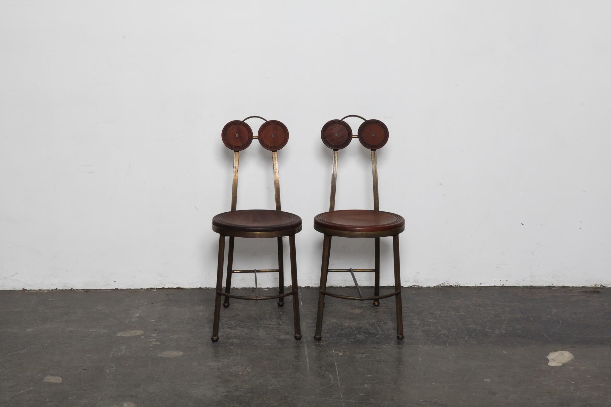 Pair of rare solid solid bronze and Freijo wood side chairs, made in Brazil by designer Pedro Useche. Very unique chairs with solid wood dual circles for the back support and a large solid wood round seat. Frames are very heavy for their size.
