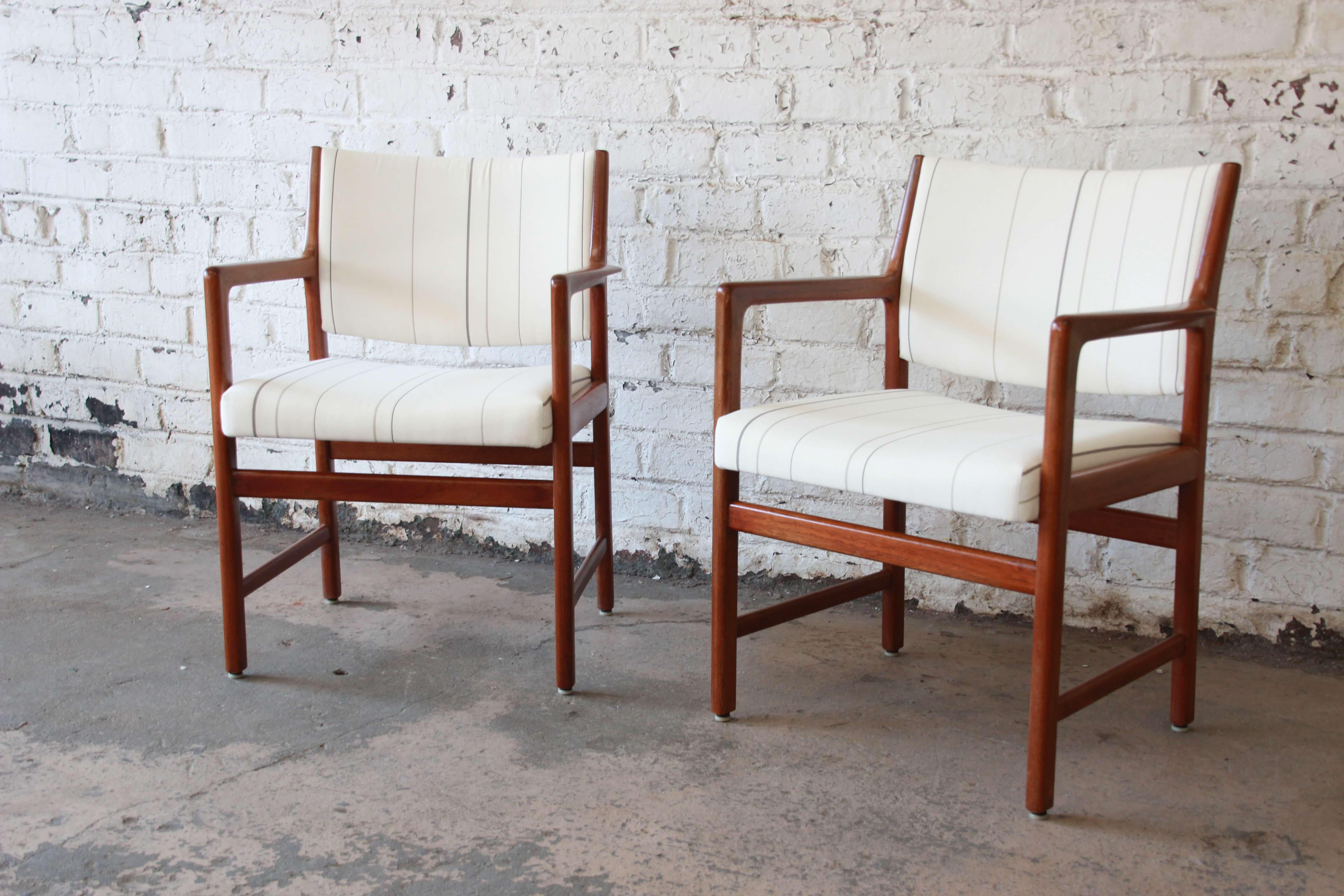 Offering a very nice pair of Swedish modern solid teak arm chairs by Karl Erik Ekselius. The chairs are made from solid teak with a nice wide frame and arm rest for added comfort. The upholstery is clean and the chairs sit comfortably and the foam