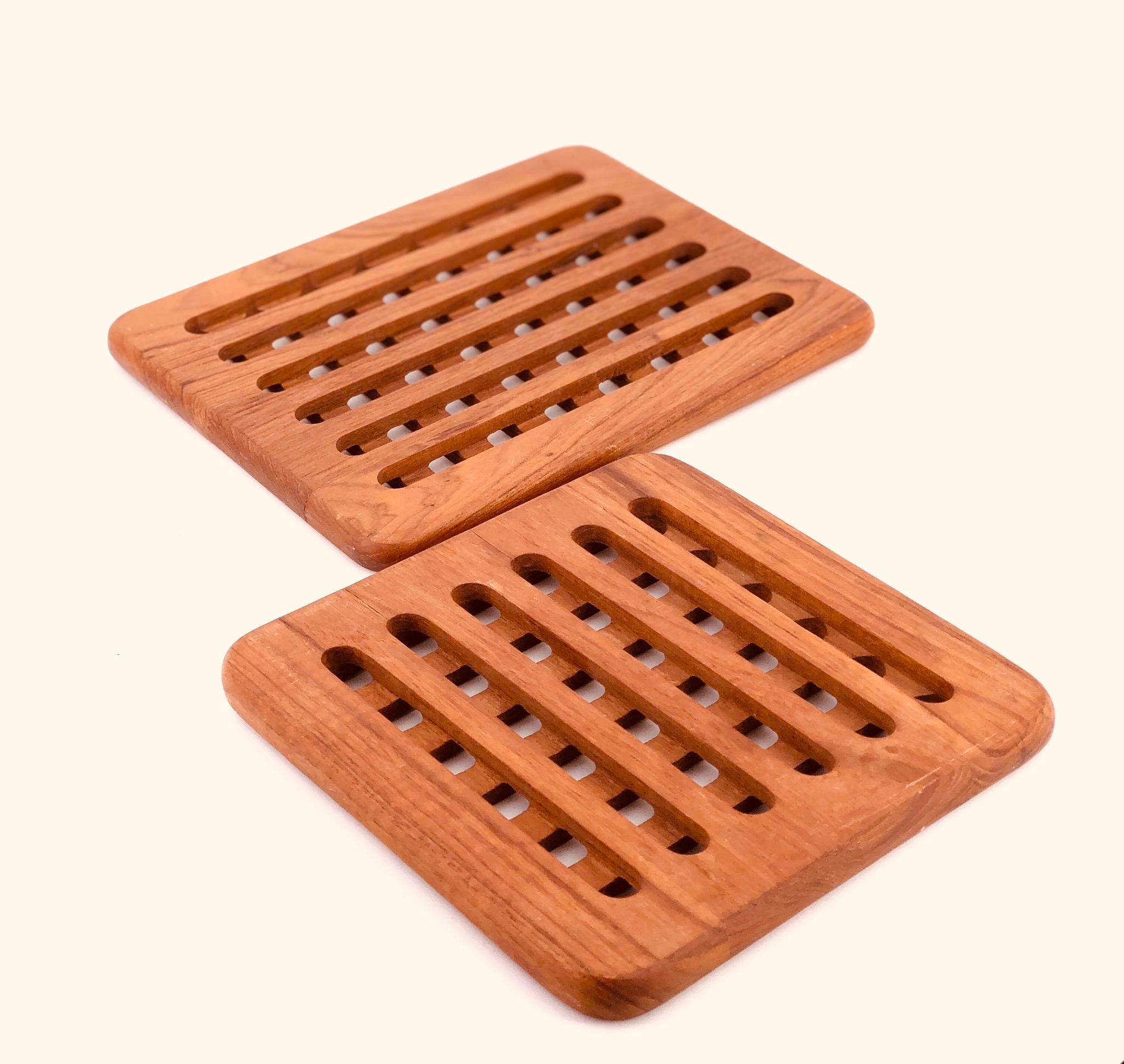 Nice pair of Danish teak trivets circa 1980s, made of solid teak incredible craftsmanship. The small one is 7.75