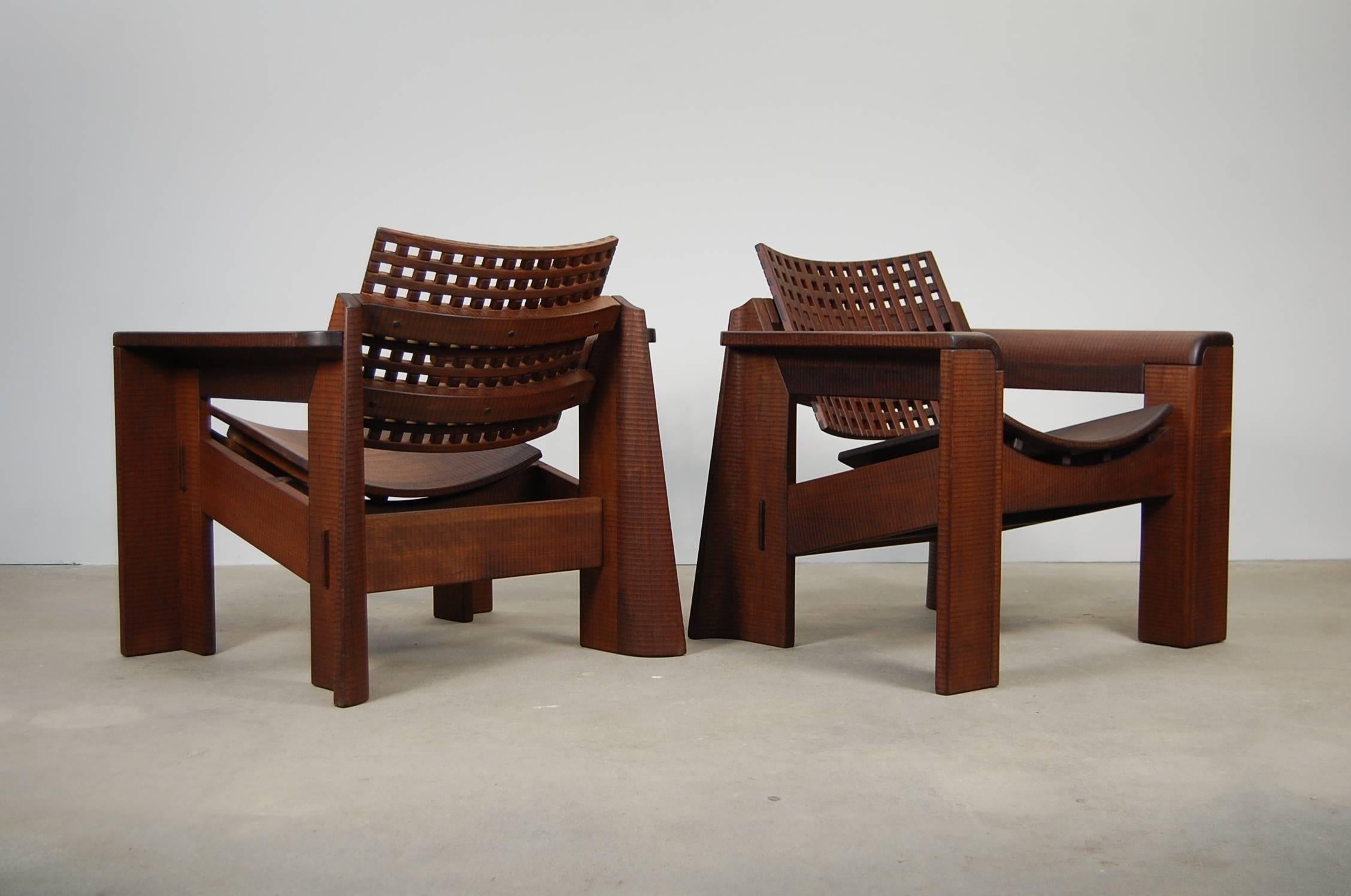 Pair of studio made lounge chairs in solid, chip carved black walnut. Through tenons and dovetail slip joints speak to the quality of the construction on these chairs. Every surface is chip carved, with the exception of the grid backs. Very