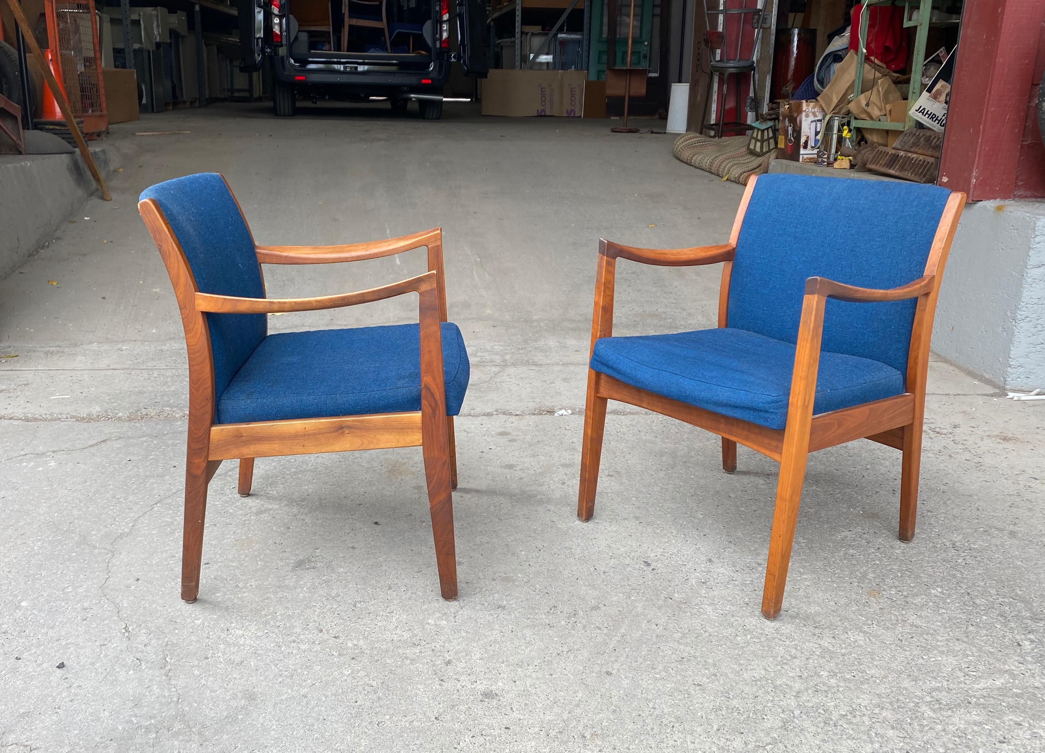 Cette superbe paire de fauteuils vintage modernes est dotée de superbes cadres en noyer, d'accoudoirs sculptés et de dossiers rembourrés. Conserve le tissu de laine bleu d'origine dans un bel état d'origine. Une conception merveilleuse qui assure le