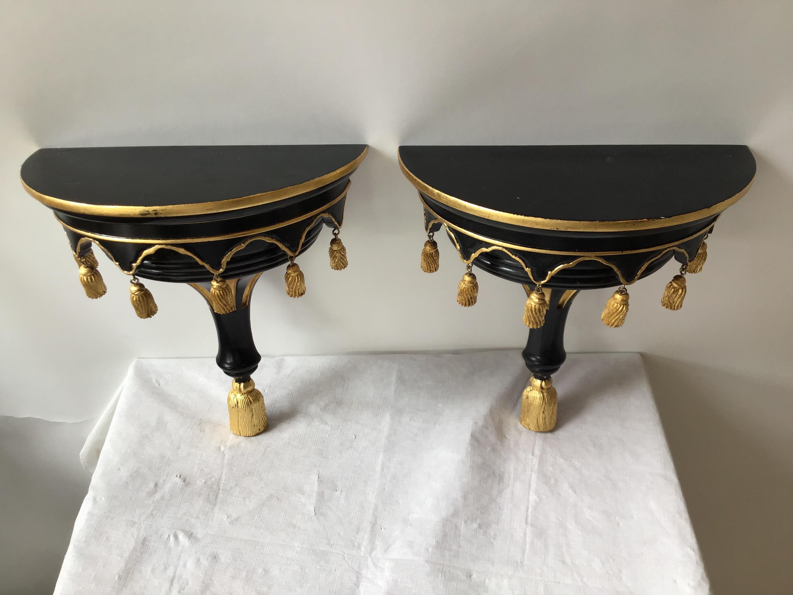 Pair of solid wood wall shelves with gilt tassels.