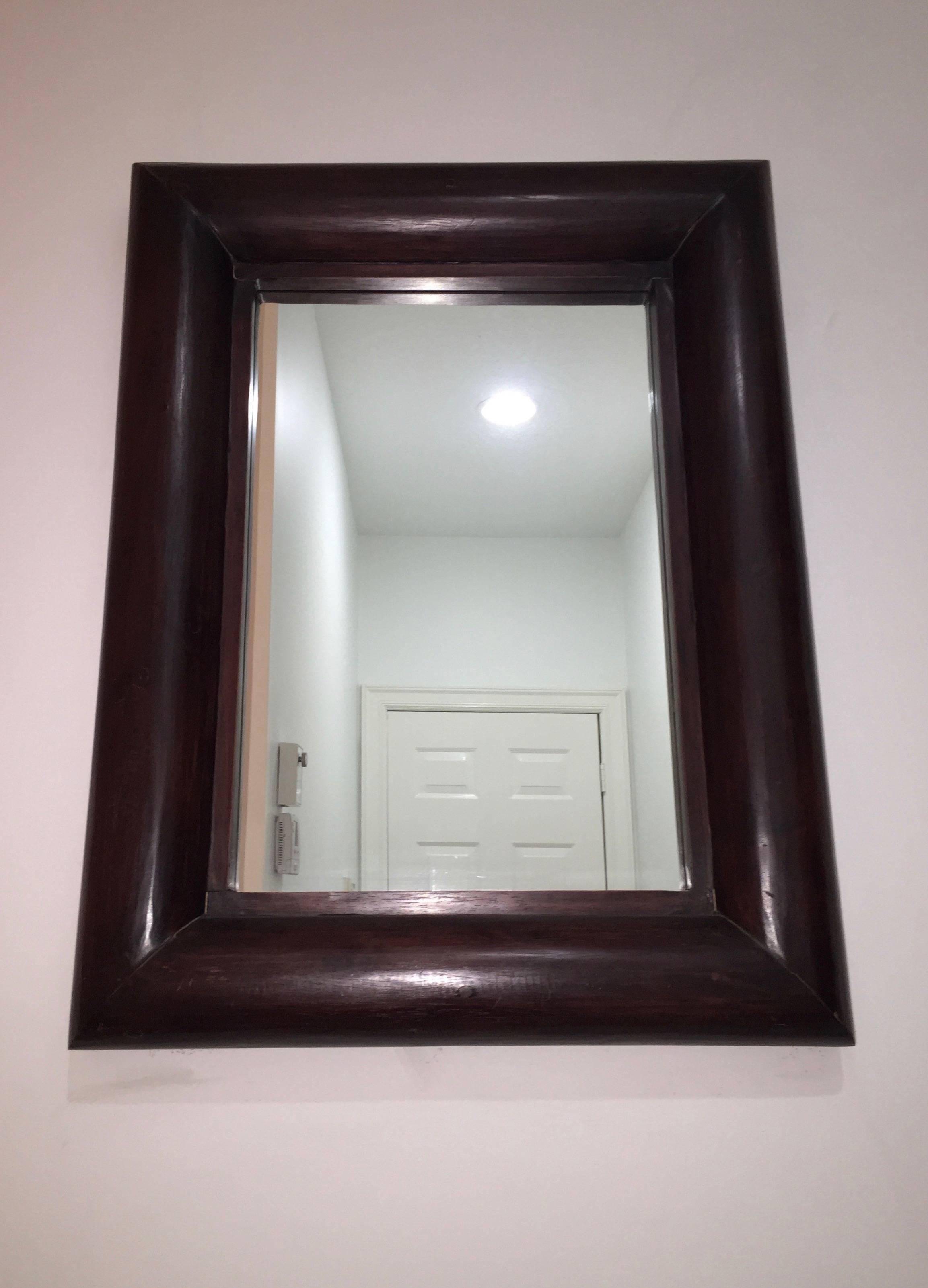 Pair of rounded edge, solid wood rectangular mirrors with an inside trim of the same wood framing the center mirrored glass.