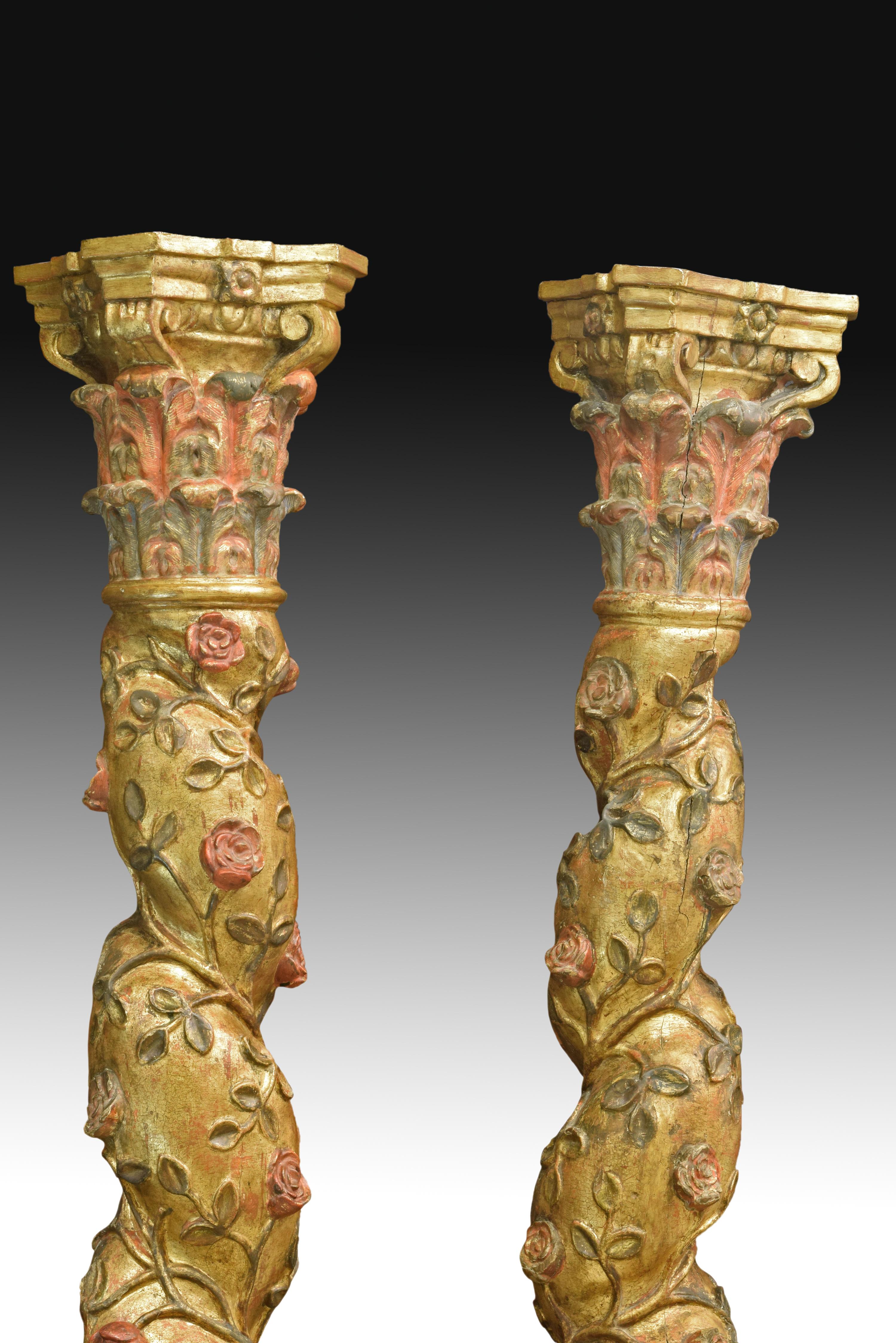 Pair of decorative carved and gilded wooden columns with a pedestal in green tones, decorated with smooth moldings, Solomonic shaft decorated with roses and polychrome leaves on the golden background and in slight relief and capitals similar to