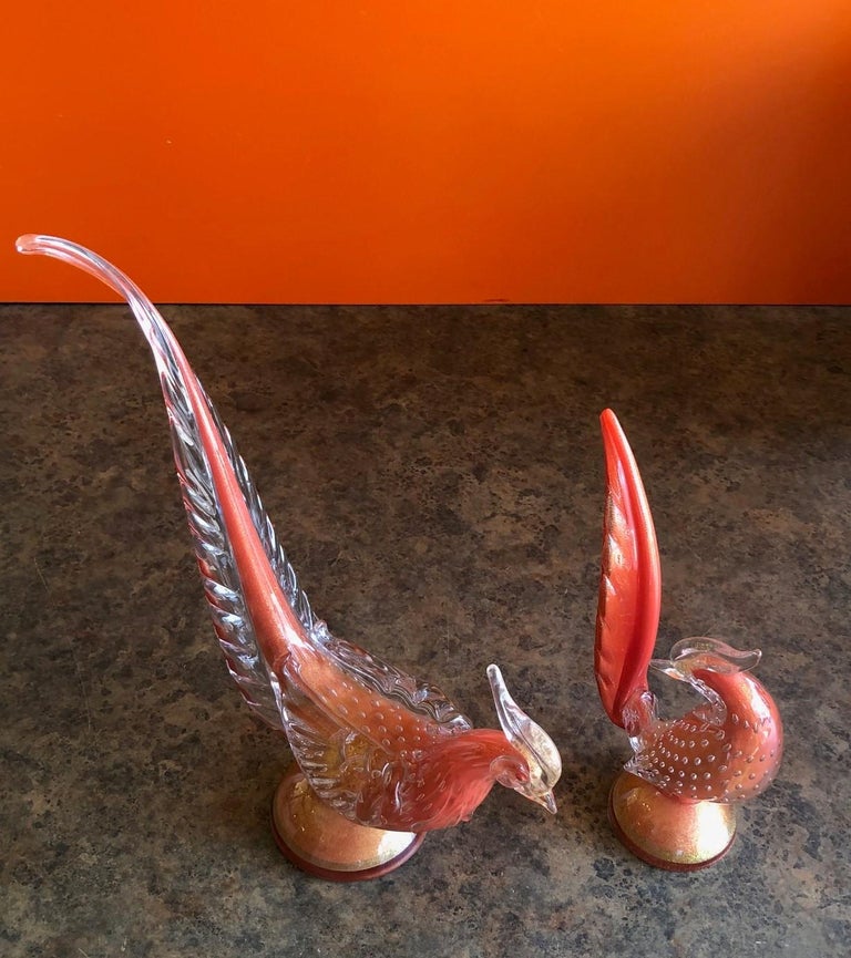 Nice pair of art glass birds / pheasants by Murano glass studios, circa 1970s in a orange / clear Sommerso style glass with gold speckles. The larger bird measures 14.5