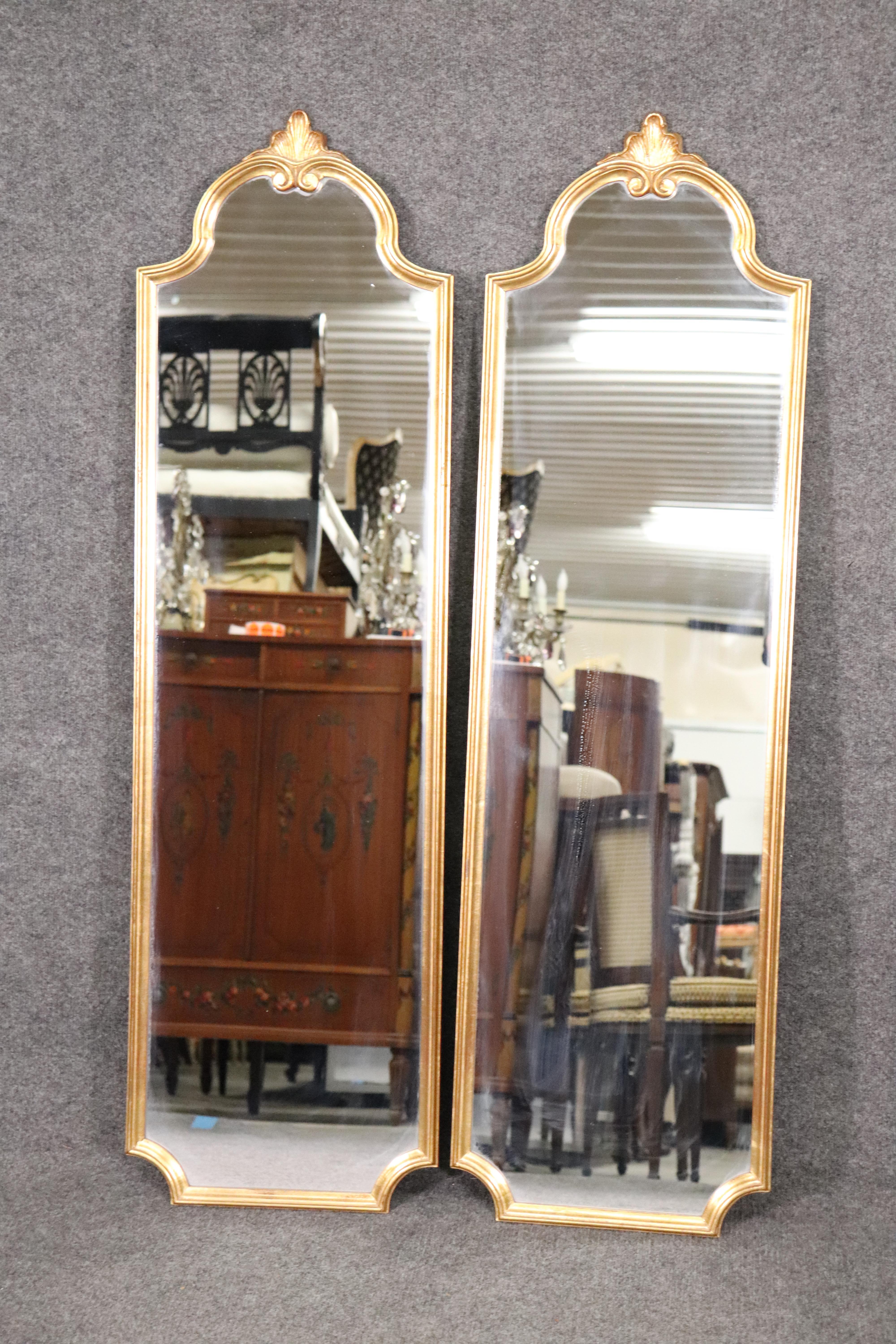 This is a very chic and sophisticated pair of very narrow gilded wood mirrors. They are minimalist and not overly carved or overly embellished. They are perfect for any area that can't be overpowered by more heavily carved mirrors. The mirrors are